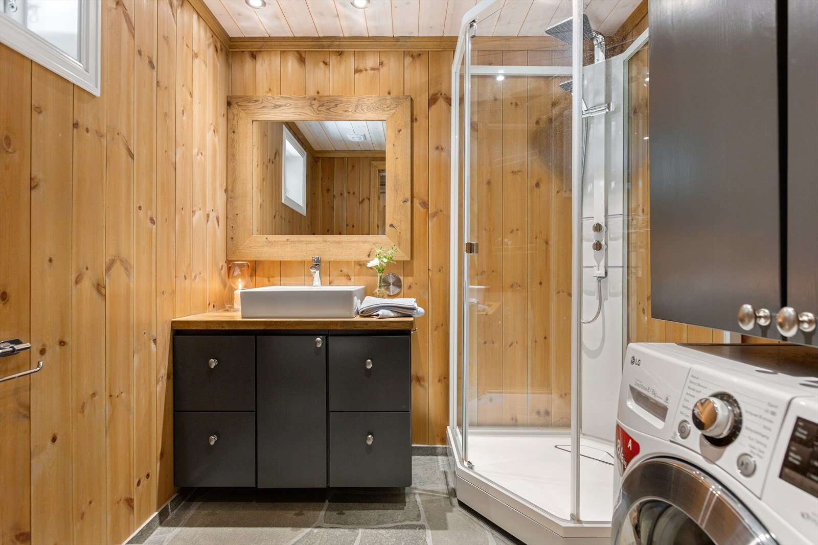 Badet har baderomsinnredning i heltre med underskap, servant, heltre benkeplate i eik og speil. Toalett, dusjkabinett og opplegg til vaskemaskin. Galleribilde