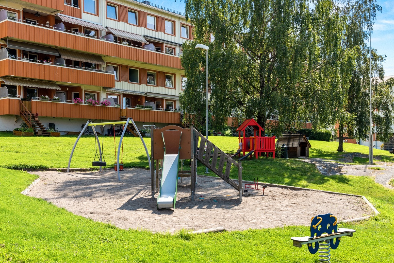 Fellesarealene er pent opparbeidet med store plener, sittebenker og en fin lekeplass til de små. Galleribilde