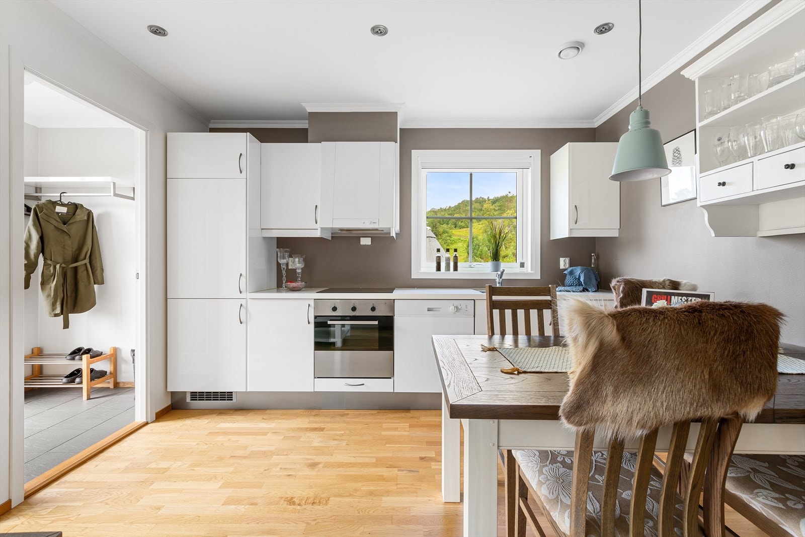 Kjøkkenet er moderne og velutstyrt, med hvite fronter og integrerte hvitevarer som gir et rent og stilrent uttrykk Galleribilde