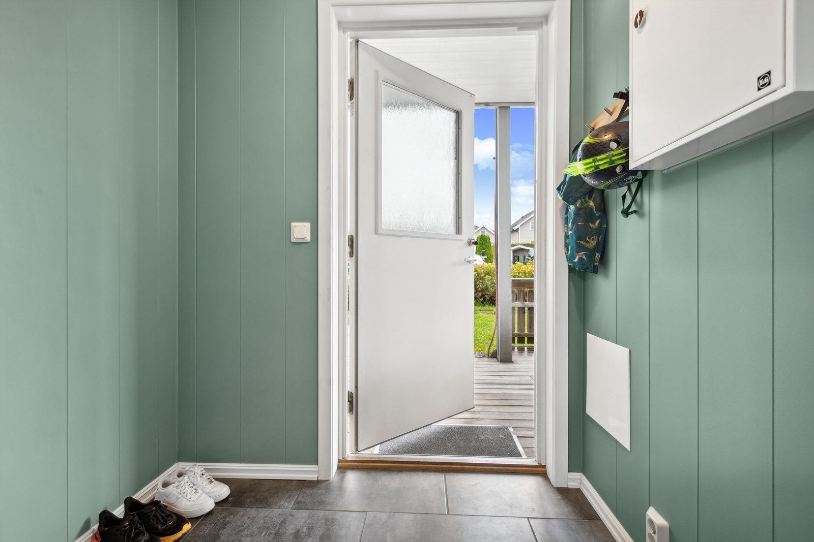 Det er adkomst til leiligheten fra bakkeplan og inn i første etasje. Velkommen inn - her ønskes du velkommen inn i lys entrè med plass til å henge fra deg ytterklær. Galleribilde