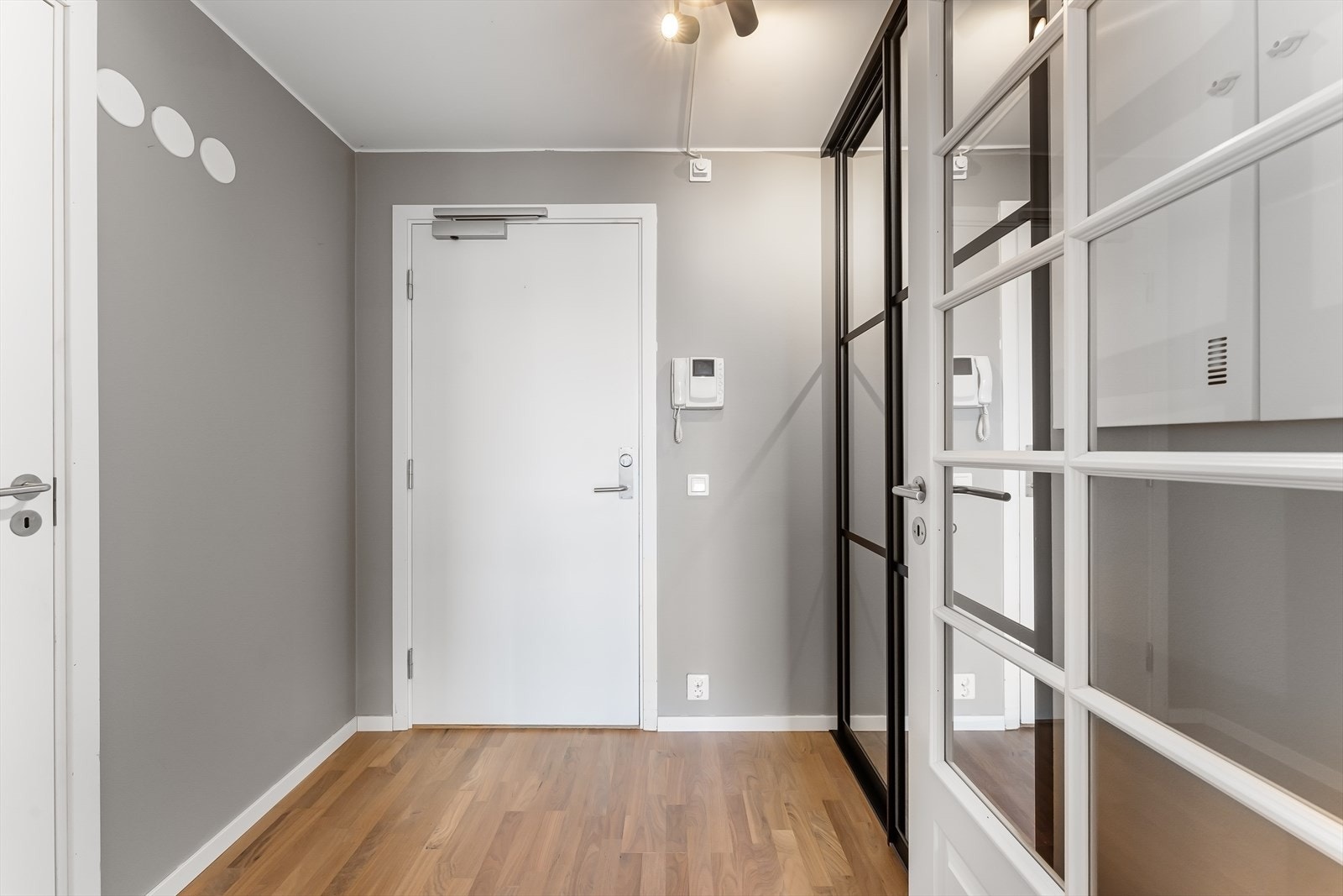 Man ønskes velkommen inn i en praktisk entré. Her er det skyvedørsgarderobe med speildører. Porttelefon /døråpner med kamera. Sikringsskapet er plassert på veggen. Dør med glassfelt inn til stue/kjøkken. Galleribilde
