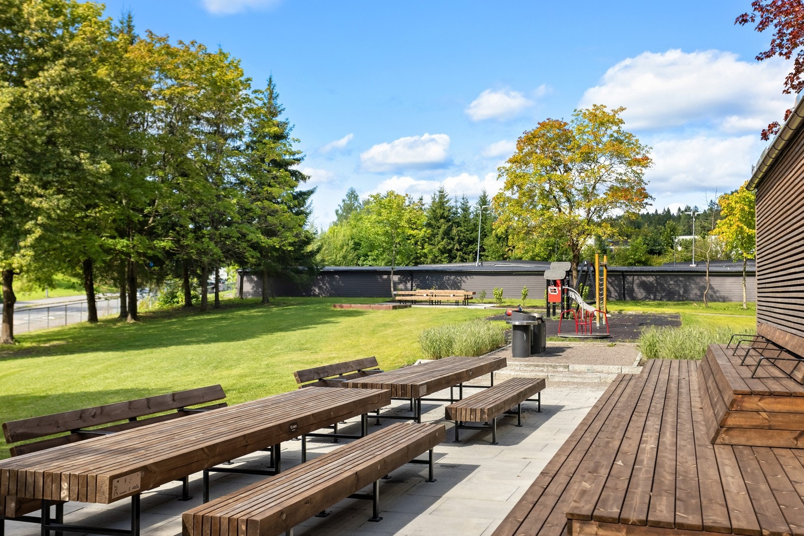 Området rundt boligen er pent opparbeidet og byr på store grøntarealer, sittegrupper og hyggelig tun med lekeapparater Galleribilde