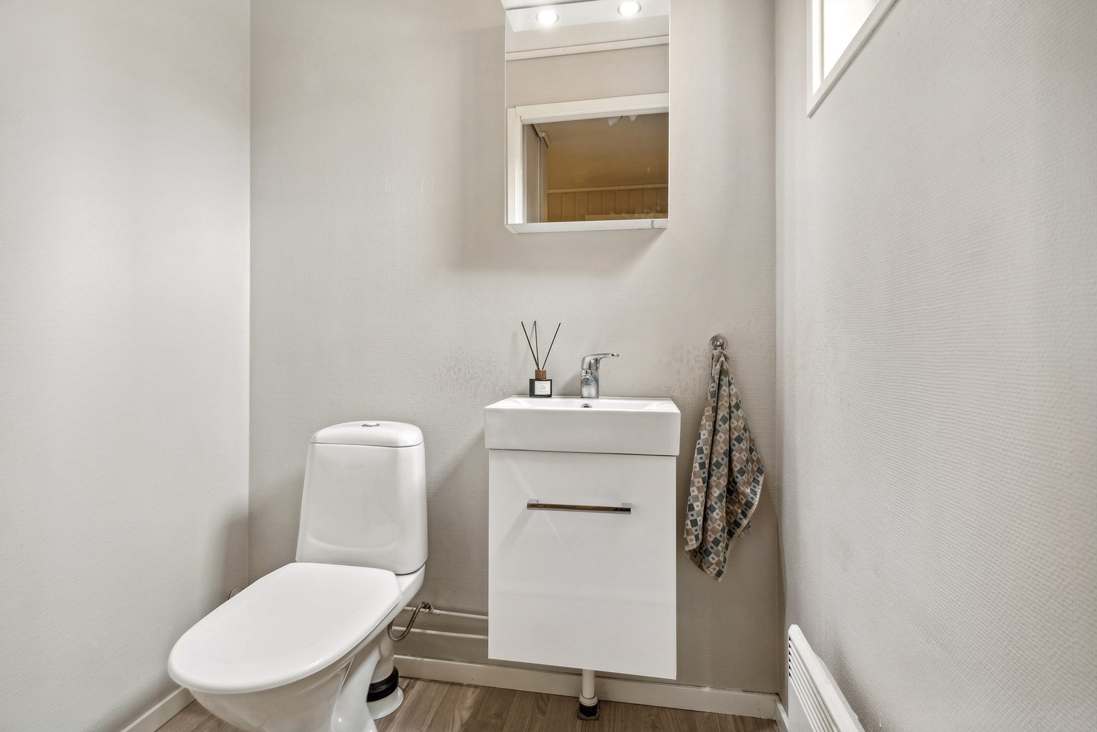 Toalettrom i første etasje med frittstående toalett og et servantskap med nedfelt vask. Galleribilde