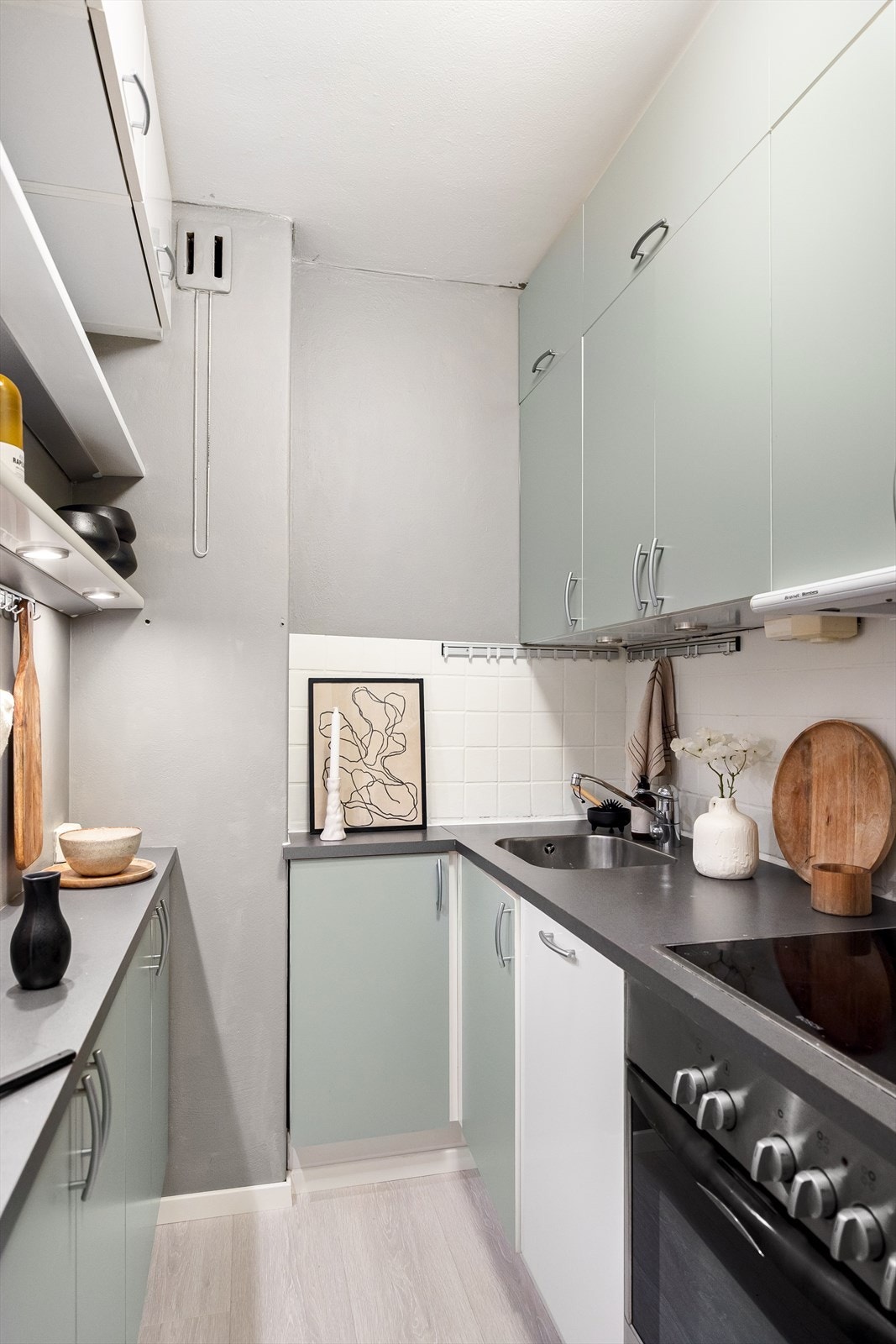 Pen innredning med glatte fronter, fliser på veggen over kjøkkenbenken og benkeplate i laminat Galleribilde