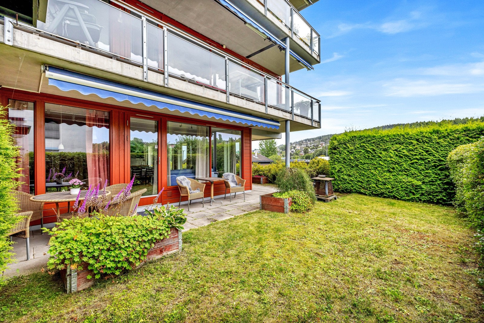 Hyggelig uteplass med terrasse og en hageflekk. Galleribilde