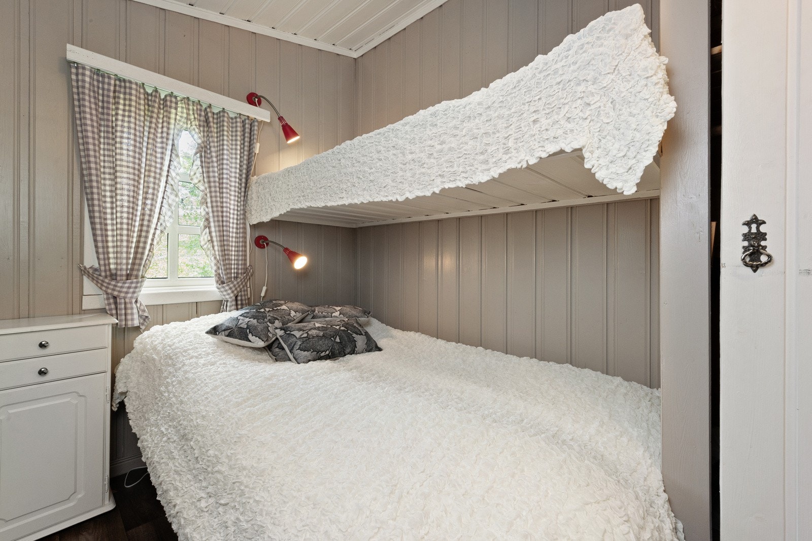 Det er to koselige soverom på hytta, begge med skråhimling, mørkt gulvbelegg og malte vegger i en varm, trendy sandfarge. Galleribilde