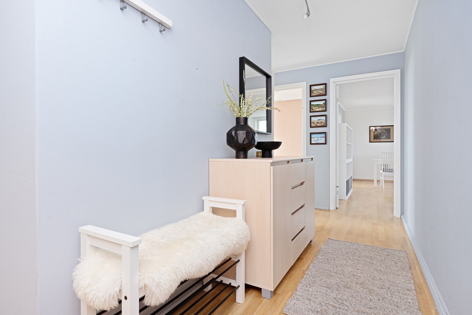 I mellomgangen er det plass til å henge fra seg yttertøy og sette fra seg sko. Legg merke til at det er gjennomgående parkettgulv og lyse duse fargetoner på vegger og i himlinger. Galleribilde