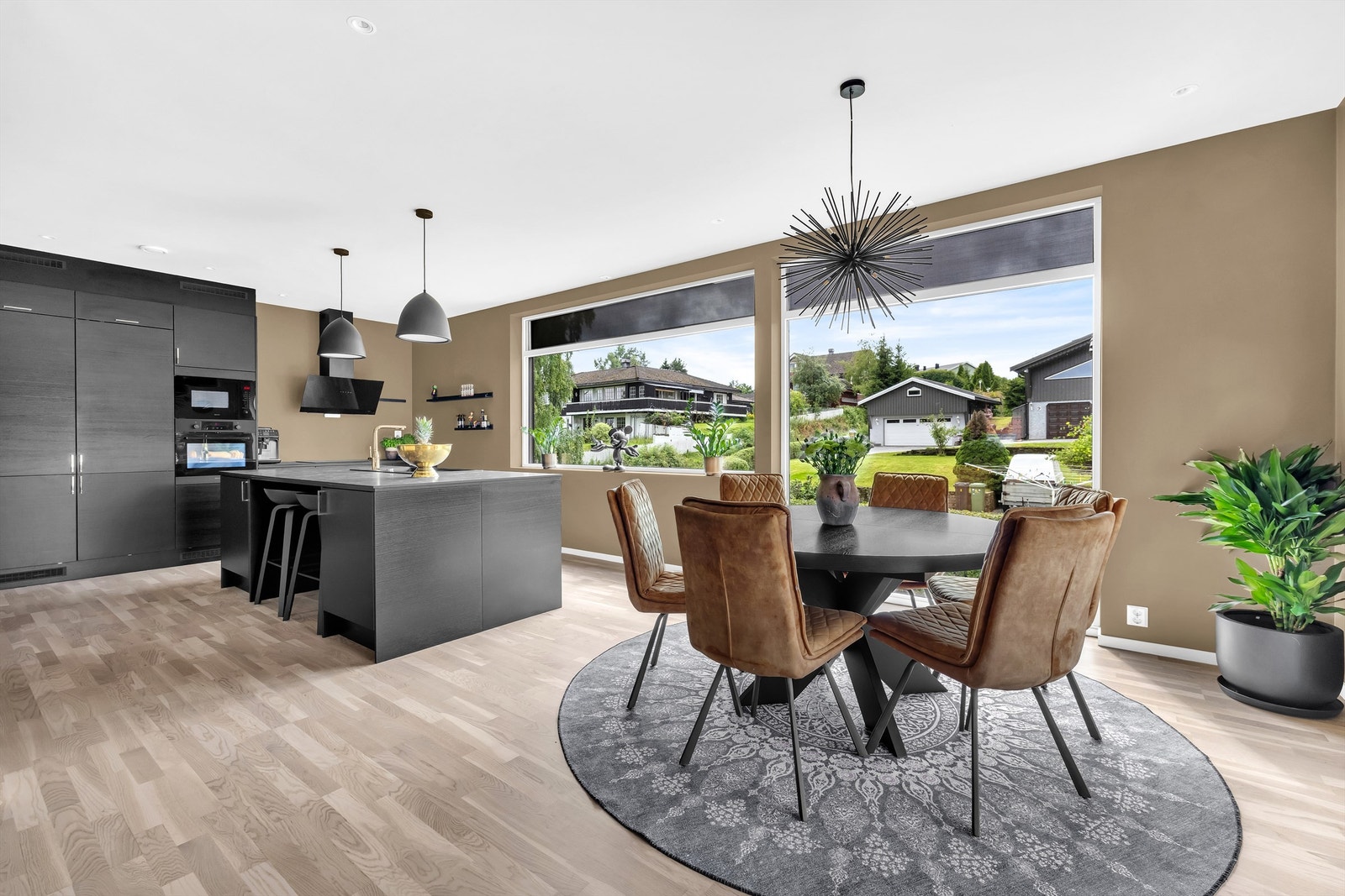 Ved kjøkkenøyen er det en hyggelig spiseplass med barstoler Galleribilde