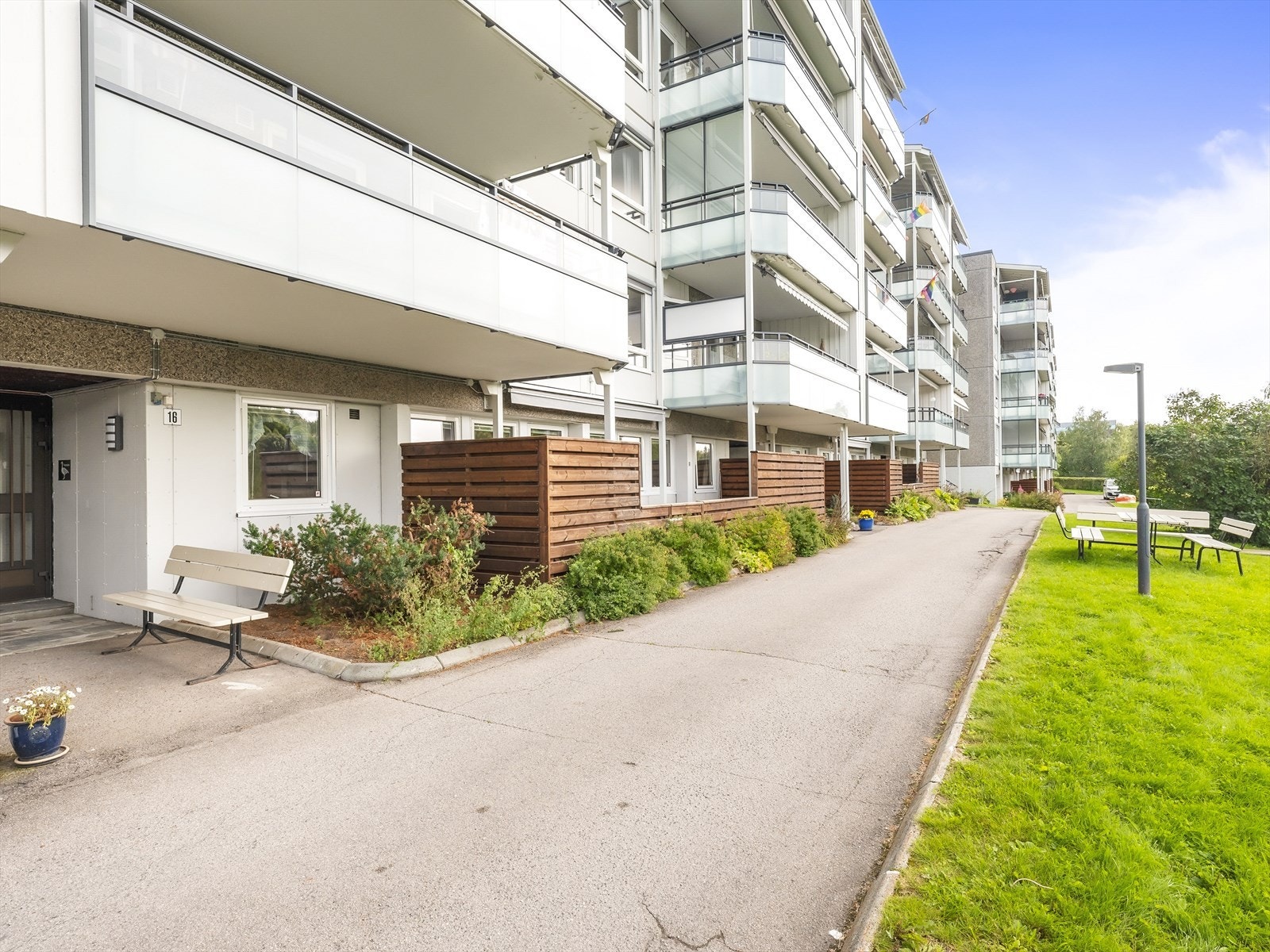 Terrassen er inngjerdet av gjerder og en busk som dekker litt av innsynet. Galleribilde