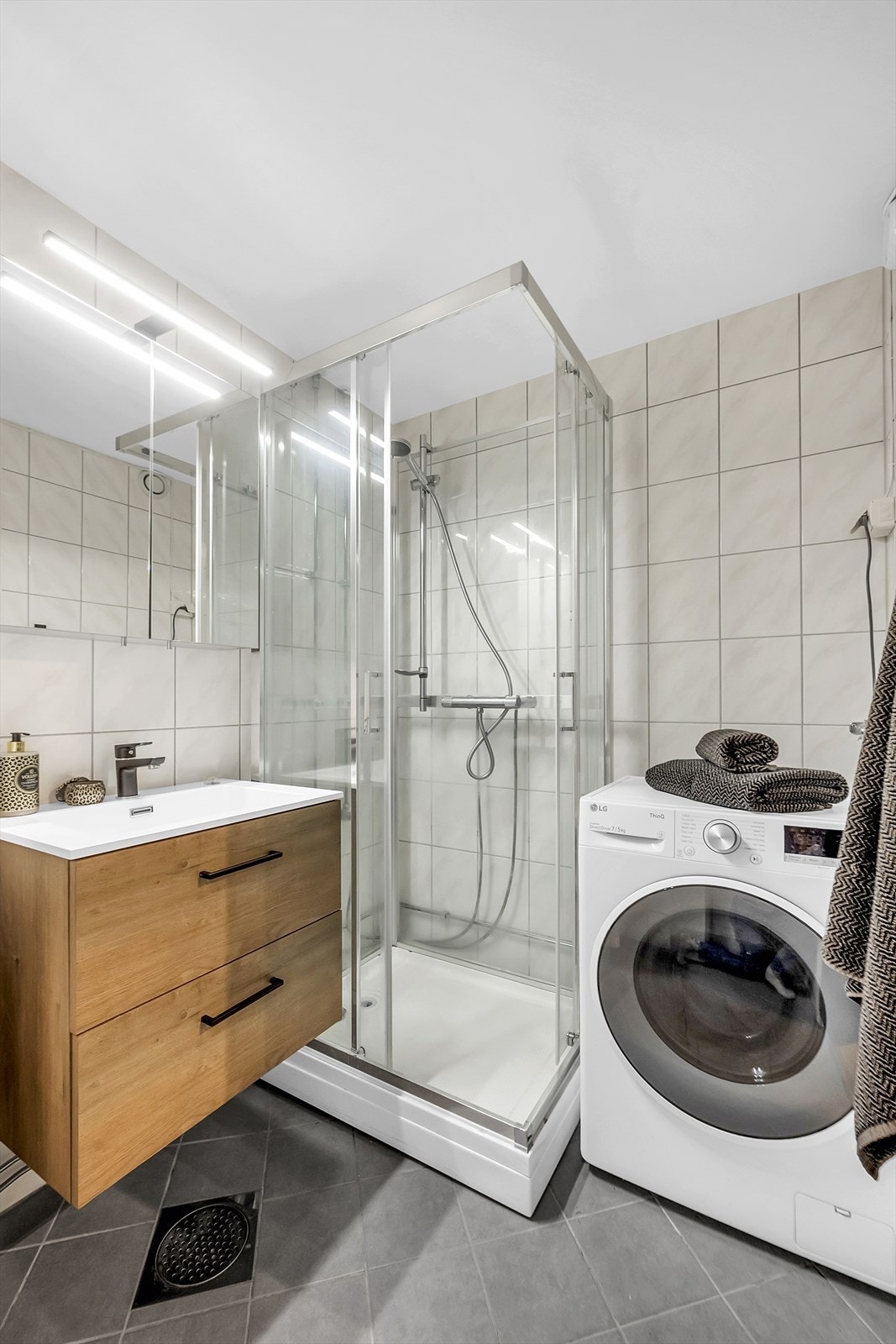 Badet har servant med oppbevaring, dusjkabinett, vegghengt wc og opplegg for vaskemaskin. Galleribilde