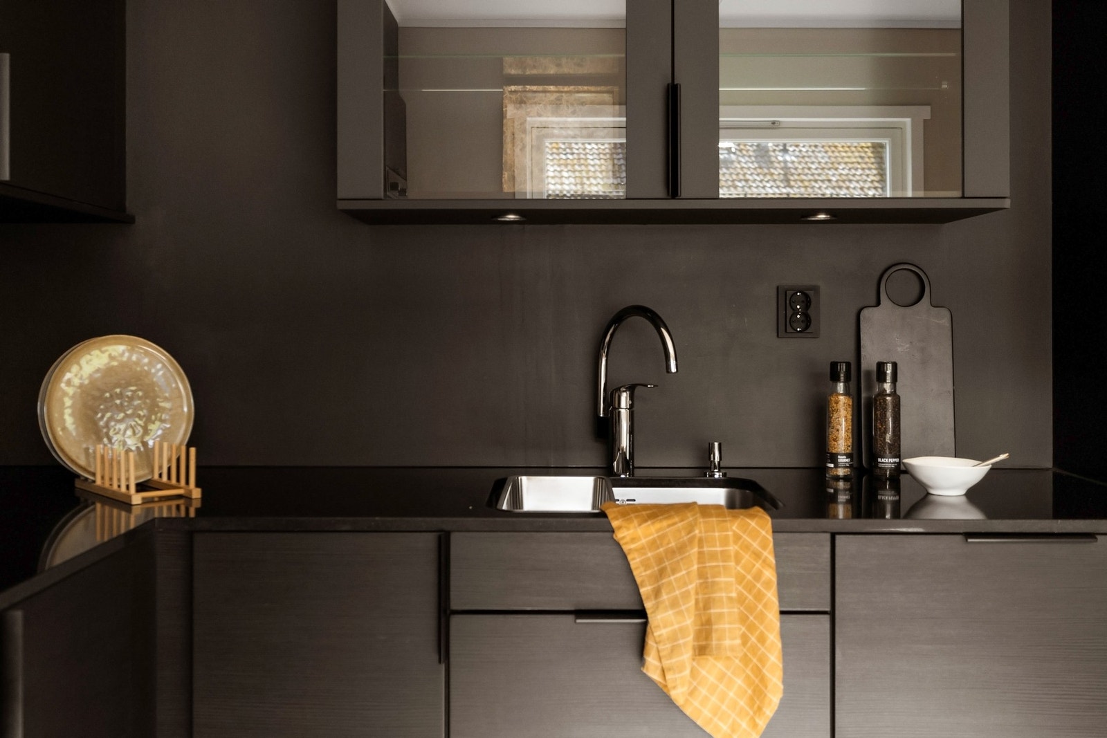 Et helsvart uttrykk i kombinasjon med lys beige gir et stilsikkert og eksklusivt preg til kjøkkenet Galleribilde