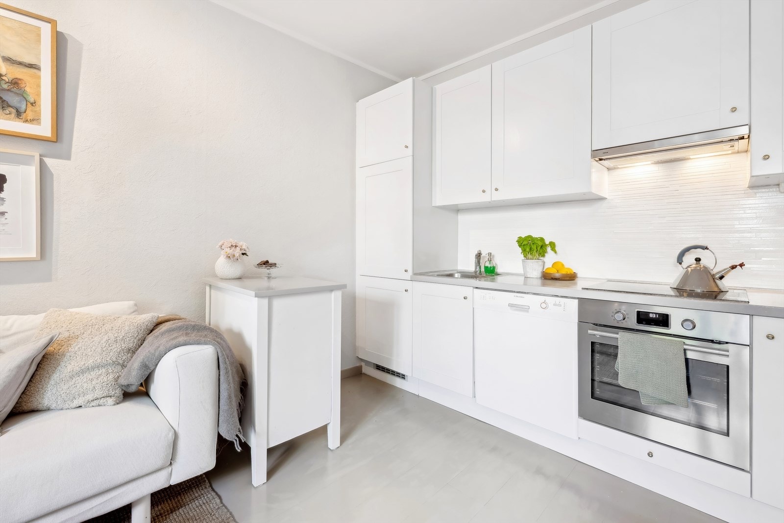 Lys kjøkkeninnredning med malte fronter og malt benkeplate i tre Galleribilde