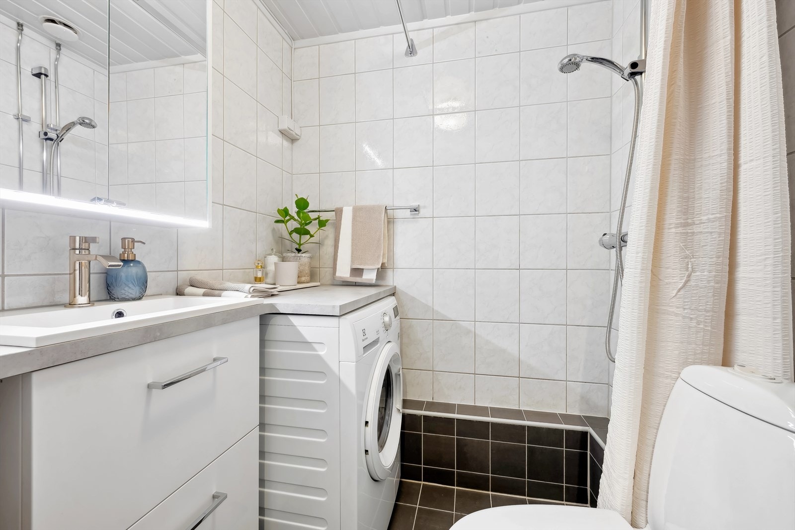 Pent flislagt bad med opplegg for vaskemaskin Galleribilde