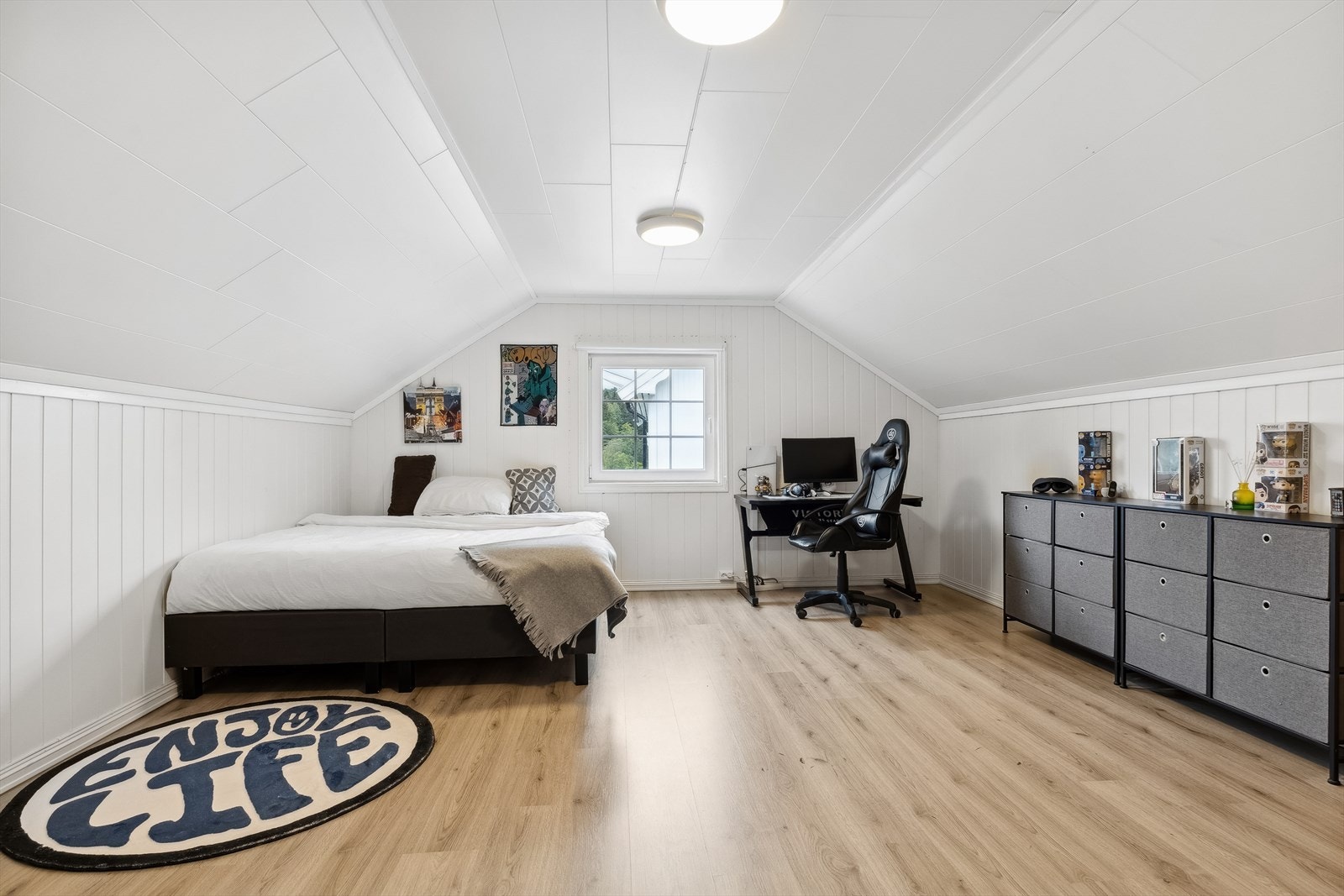 Soverom i andre etasje med laminat på gulvet og malte plater på veggene Galleribilde