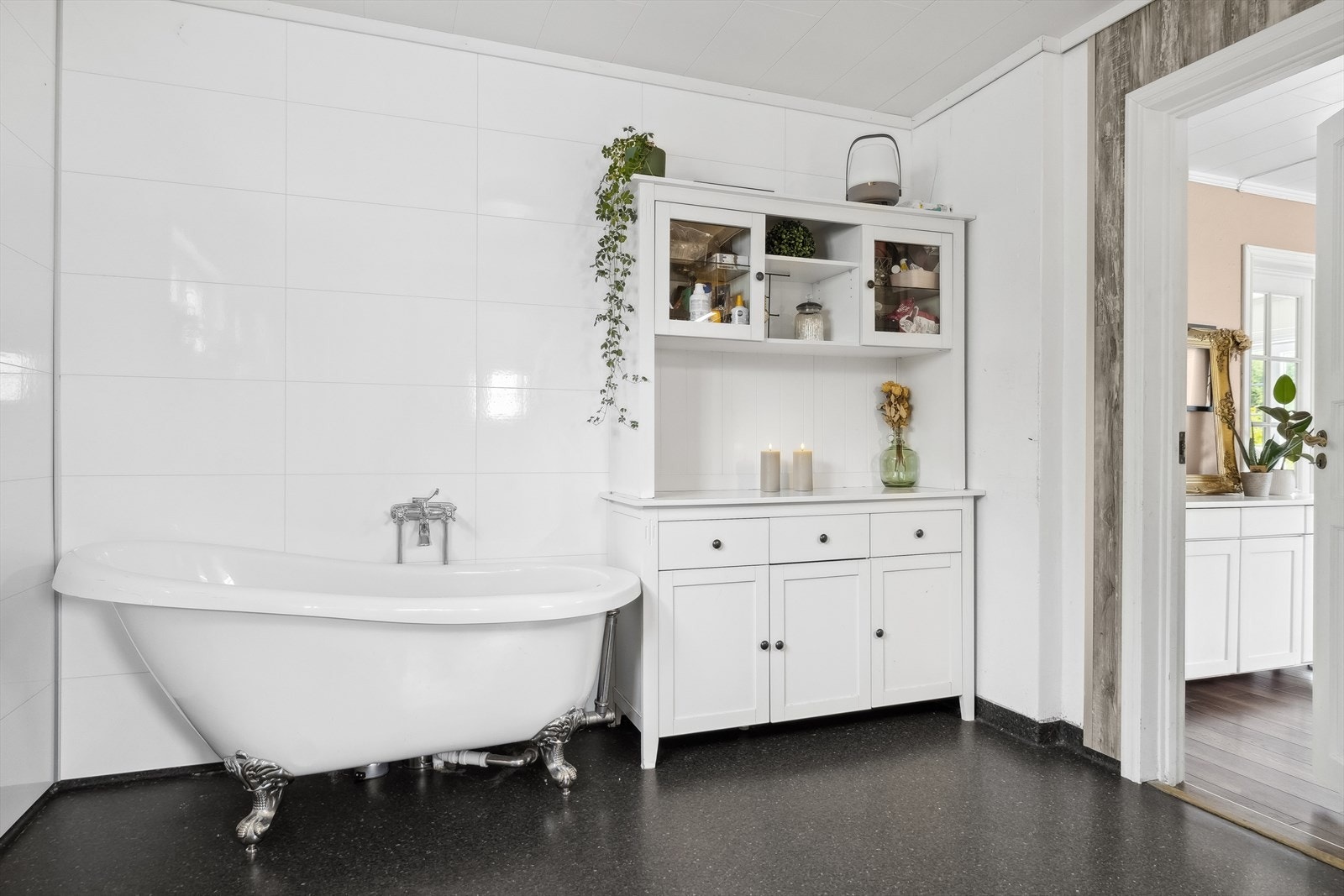 Badet ligger innenfor kjøkkenet og er et romslig rom. Det er belegg på gulvet og baderomsplater på veggene. Galleribilde