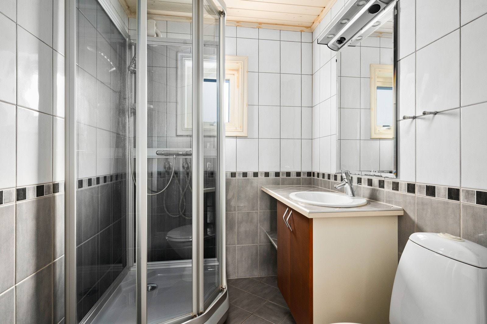 Badet har fliser på vegger og gulv og underliggende varmekabler Galleribilde