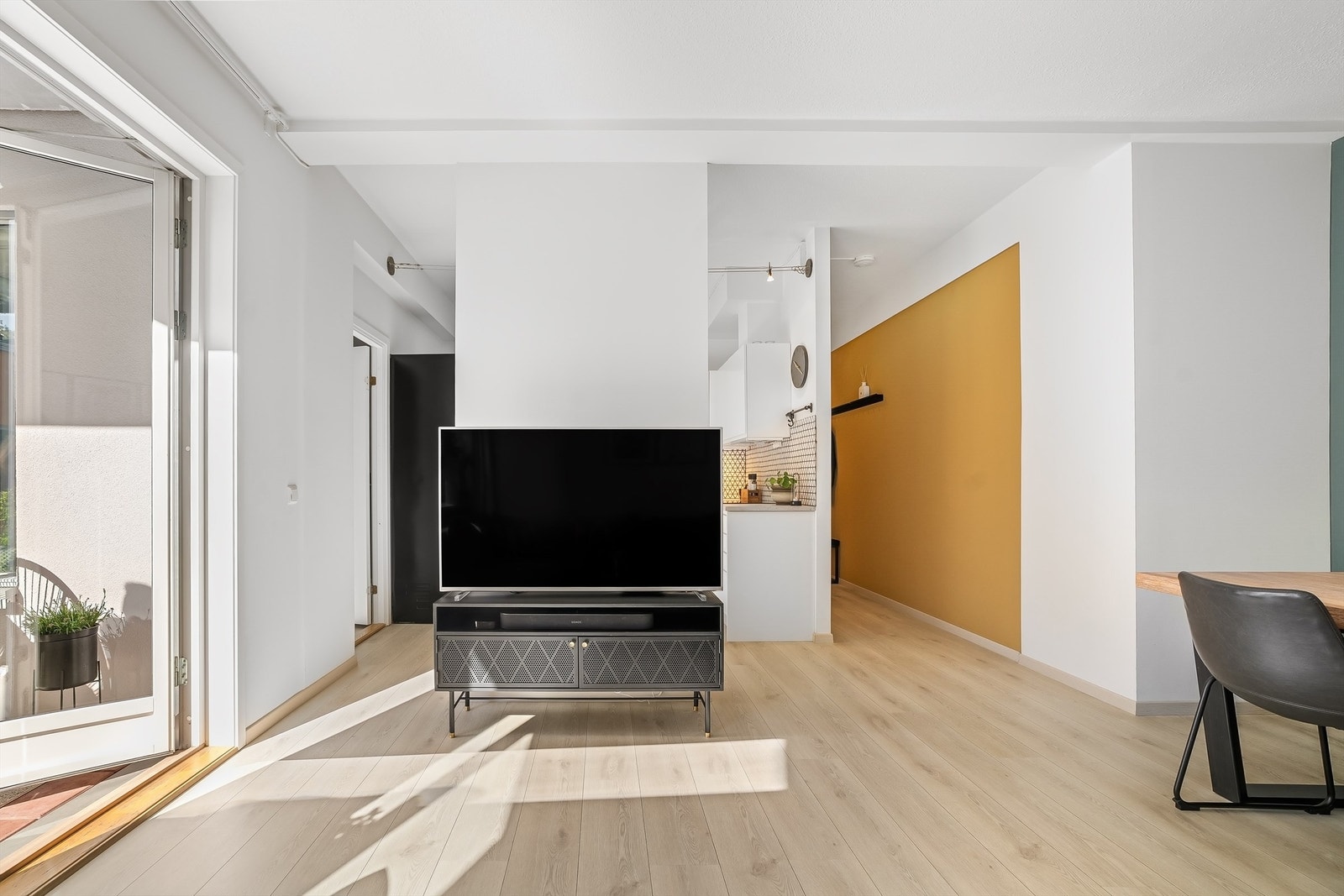 Tv-benk og oppheng til tv med naturlig plassering i tilknytning til sofagruppe. Galleribilde