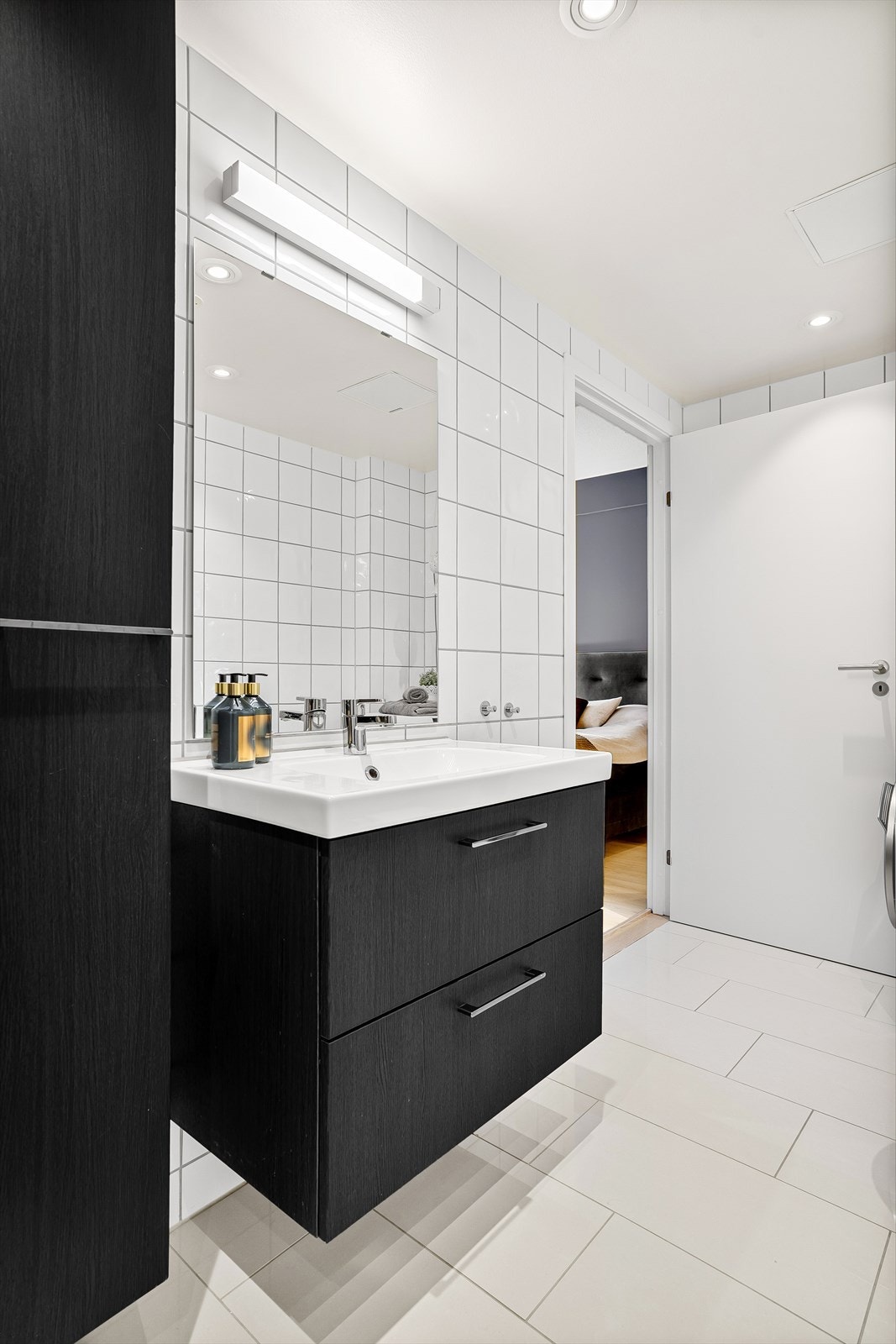 Badet er utstyrt med vegghengt servantinnredning, ovenpåliggende servant med ett-greps armatur, vegghengt speil med overlys og stikkontakt over servant. Galleribilde