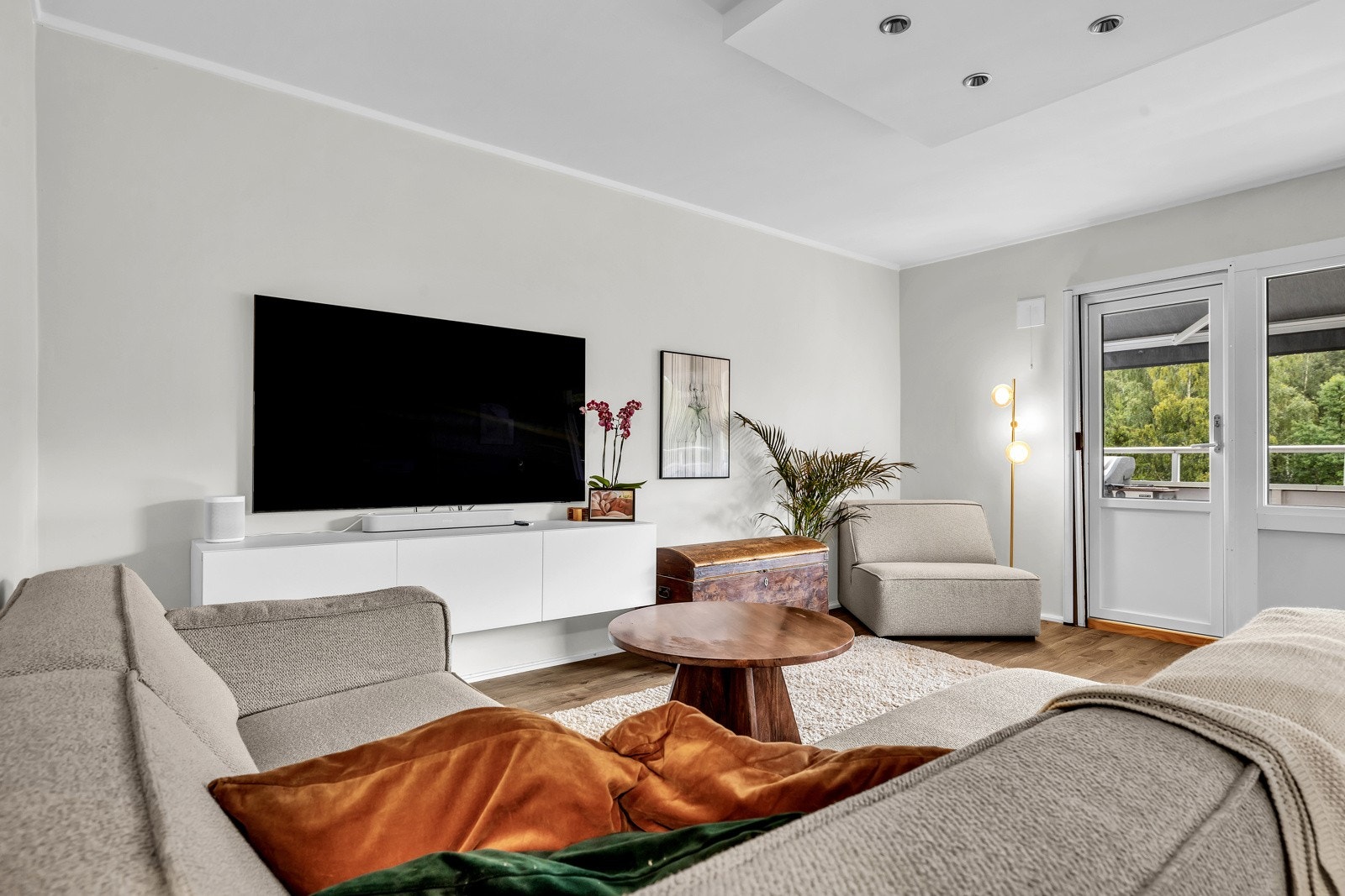 Stuen har en lys fargepalett og downlightsbelysning i taket. Galleribilde