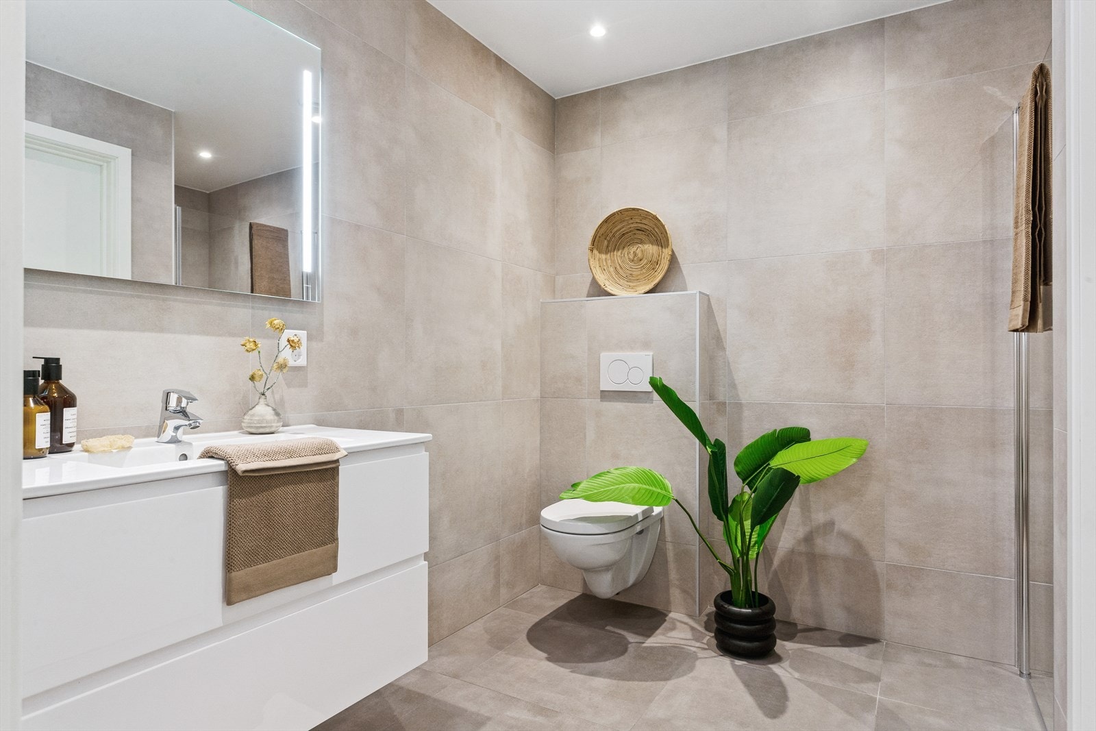 Baderom i lekker utførelse med store fliser. Det er downlights i tak og varmekabler i gulv. Galleribilde