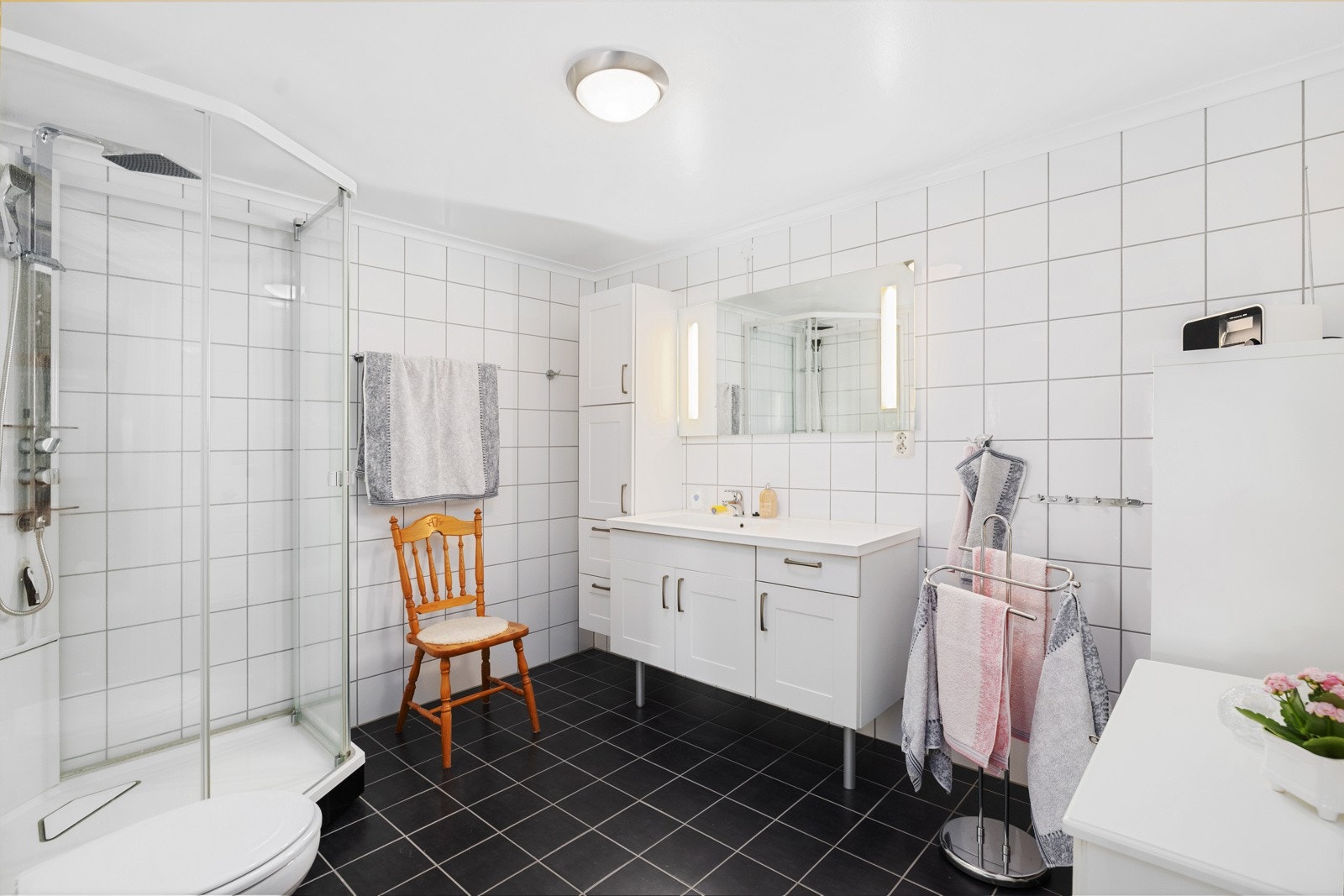 Dagene får en god start på et stort og helfliset bad med varme i gulvet. Galleribilde