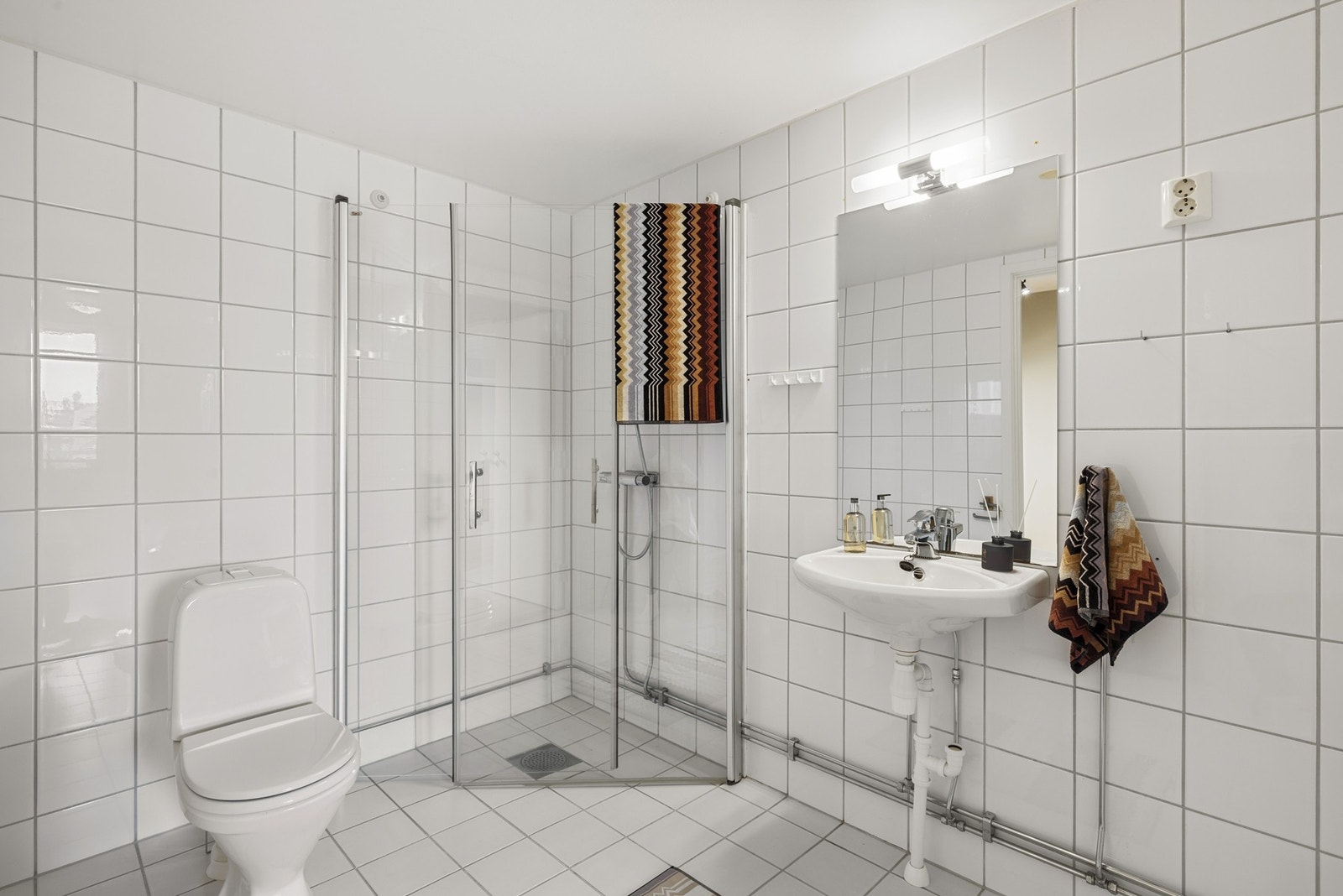 Romslig, flislagt bad med opplegg for vaskemaskin og tørketrommel. Galleribilde