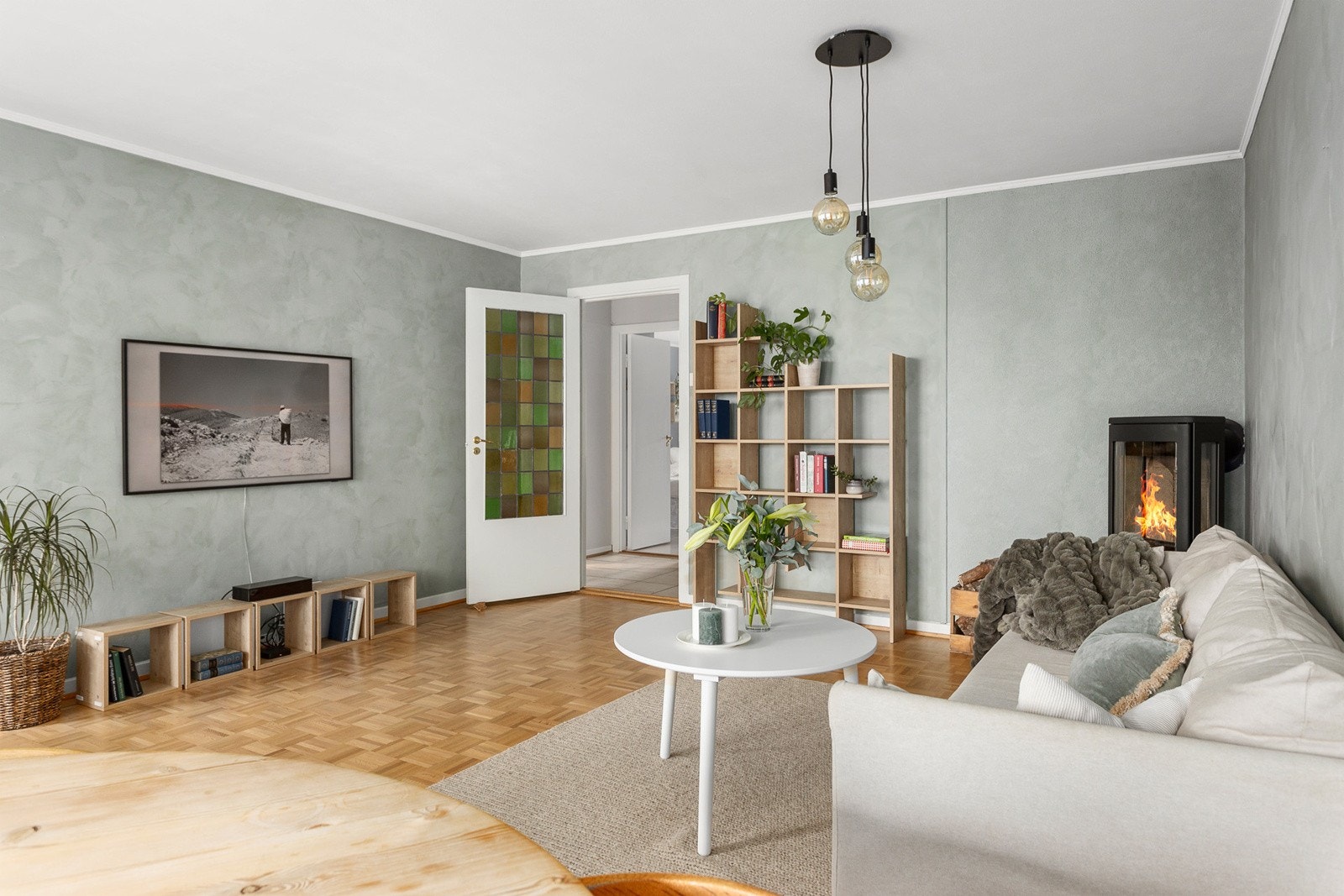Romslig og innbydende stue med parkettgulv og harmonisk fargepalett på vegger. Galleribilde