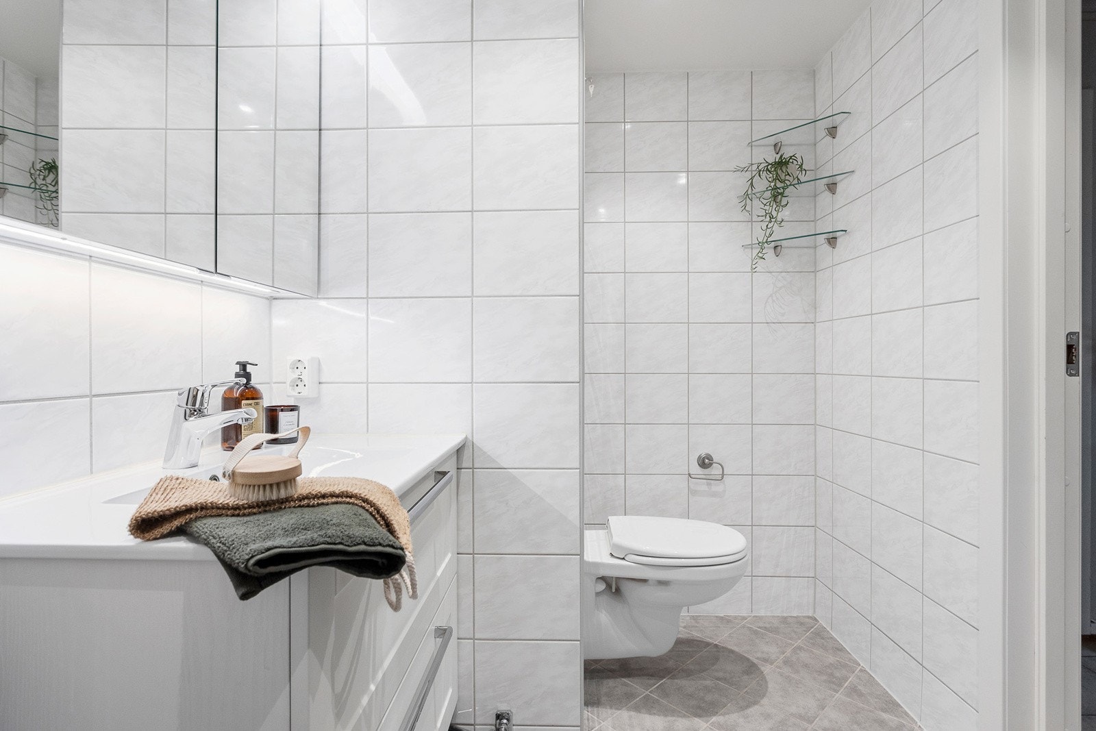 Romslig og lyst bad med gode oppbevaringsmuligheter i vegghengt servantskap og speilskap med lys. Varmekabler i gulv og downlights i himling. Galleribilde