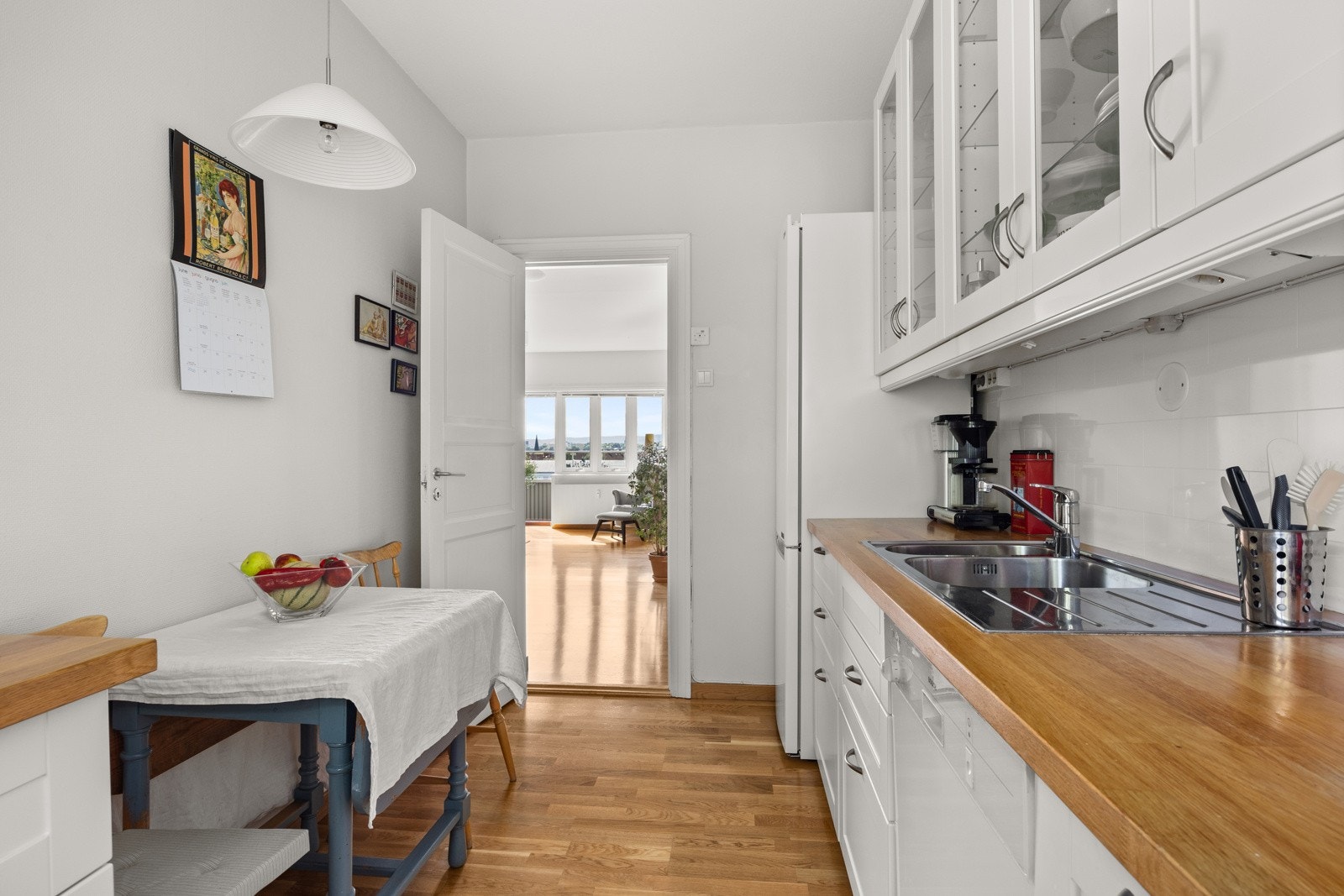 Videre utstyrt med frittstående stekeovn med platetopp, oppvaskmaskin og kjøl/frys. I rommet er det plass til et spisebord. Galleribilde