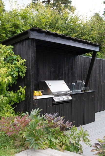 Lekkert overbygget utekjøkken med godt med oppbevaringsplass. Bilde fra magasinet Maison (utgave 04 / 2022). Fotograf Fillipa Tredal, styling av Tine Kroken. Galleribilde