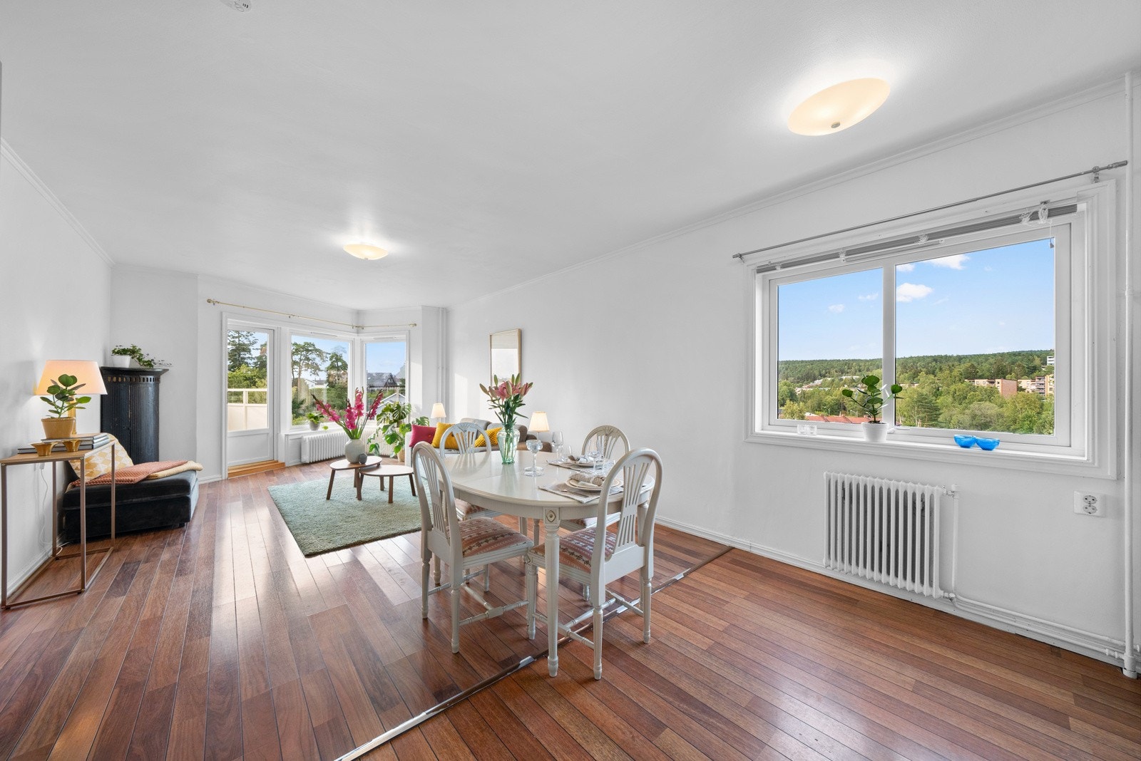 Stuen har en åpen løsning mot kjøkkenet, noe som skaper en sosial og luftig atmosfære Galleribilde