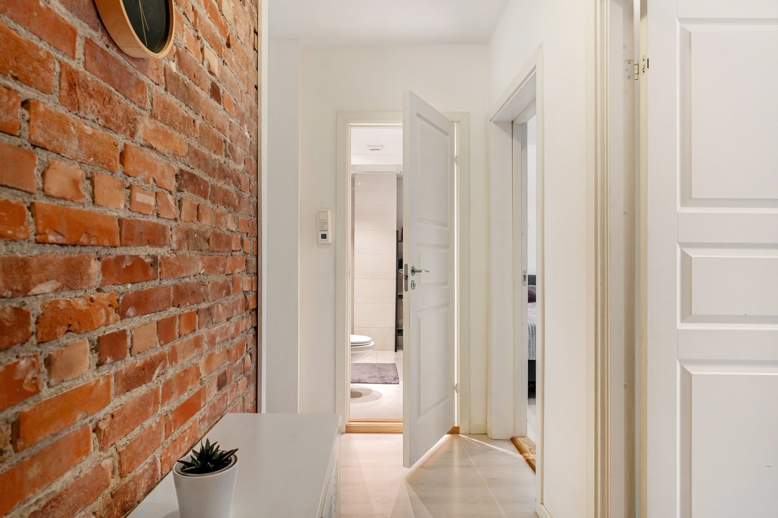 Innbydende og hyggelig entré med pen laminat på gulv og lyse farger på overflater. Galleribilde