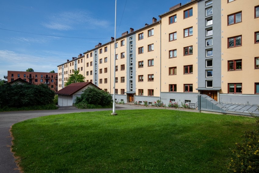 Hyggelig, felles uteområde med sittegrupper, beplantning og gressplen. Galleribilde