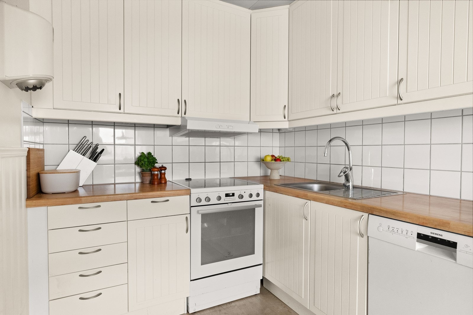 Det er satt opp belysning under overskapene og fliser på veggen. Galleribilde