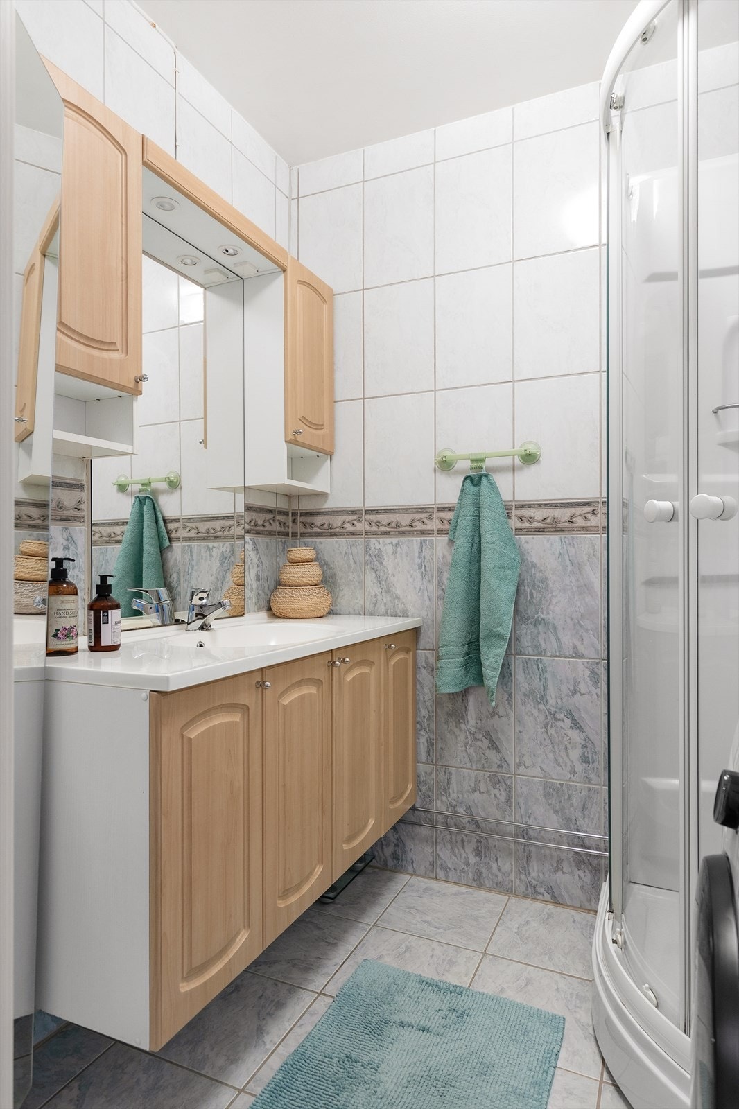 Leilighetens bad er fra byggeår og har flislagte overflater og gulvvarme. Galleribilde