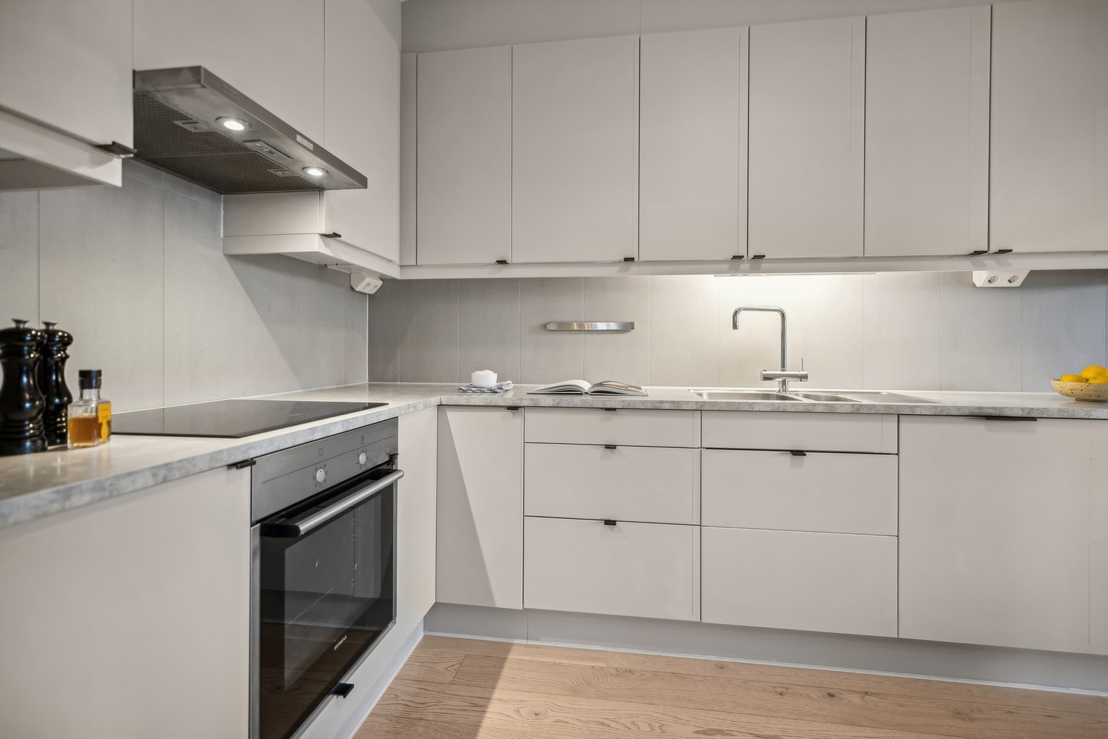 Marbodal kjøkkeninnredning med glatte fronter og laminat benkeplate med planlimt kum i rustfritt stål. Galleribilde