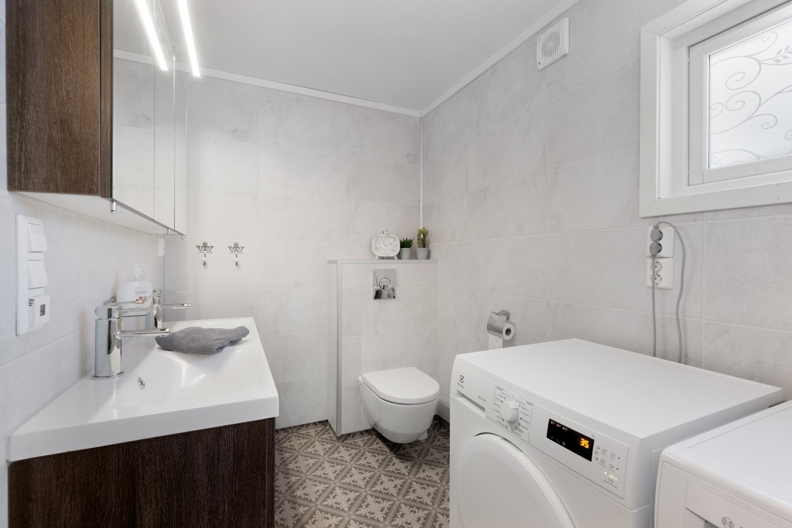 Badet er innredet med wc, badekar med dusj, og innredning med dobbel vask og skuffer under Galleribilde