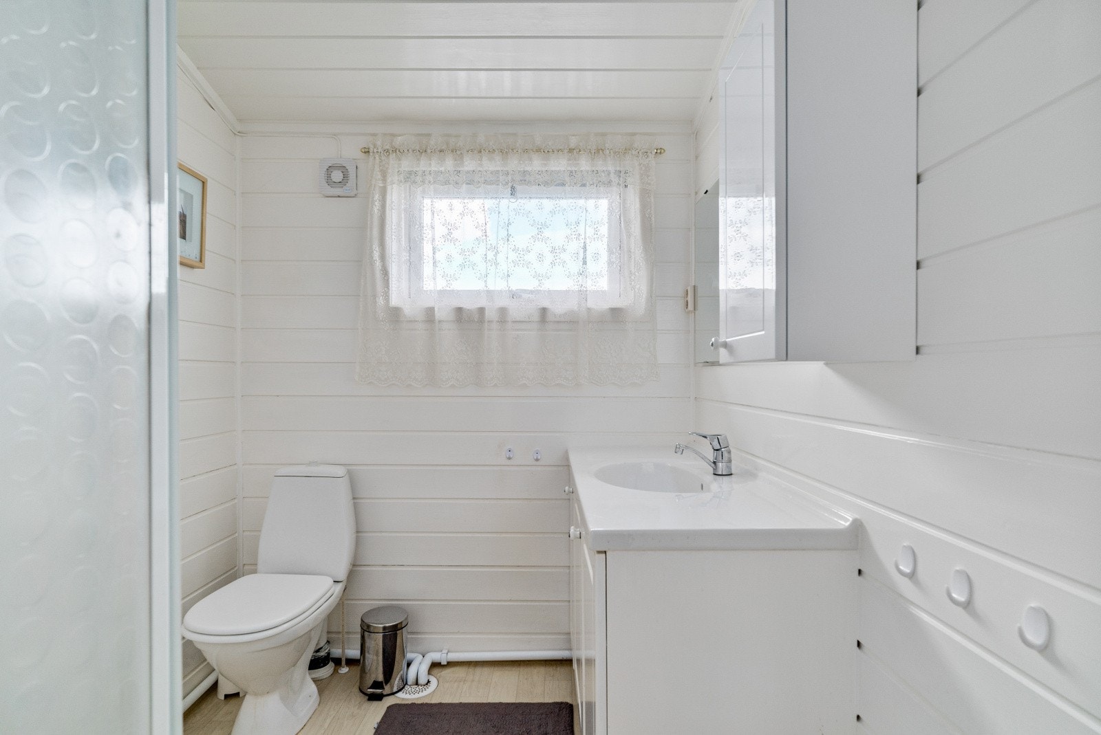 Lyst og fint hovedbad med toalett, dusj og servantinnredning med speil. Galleribilde