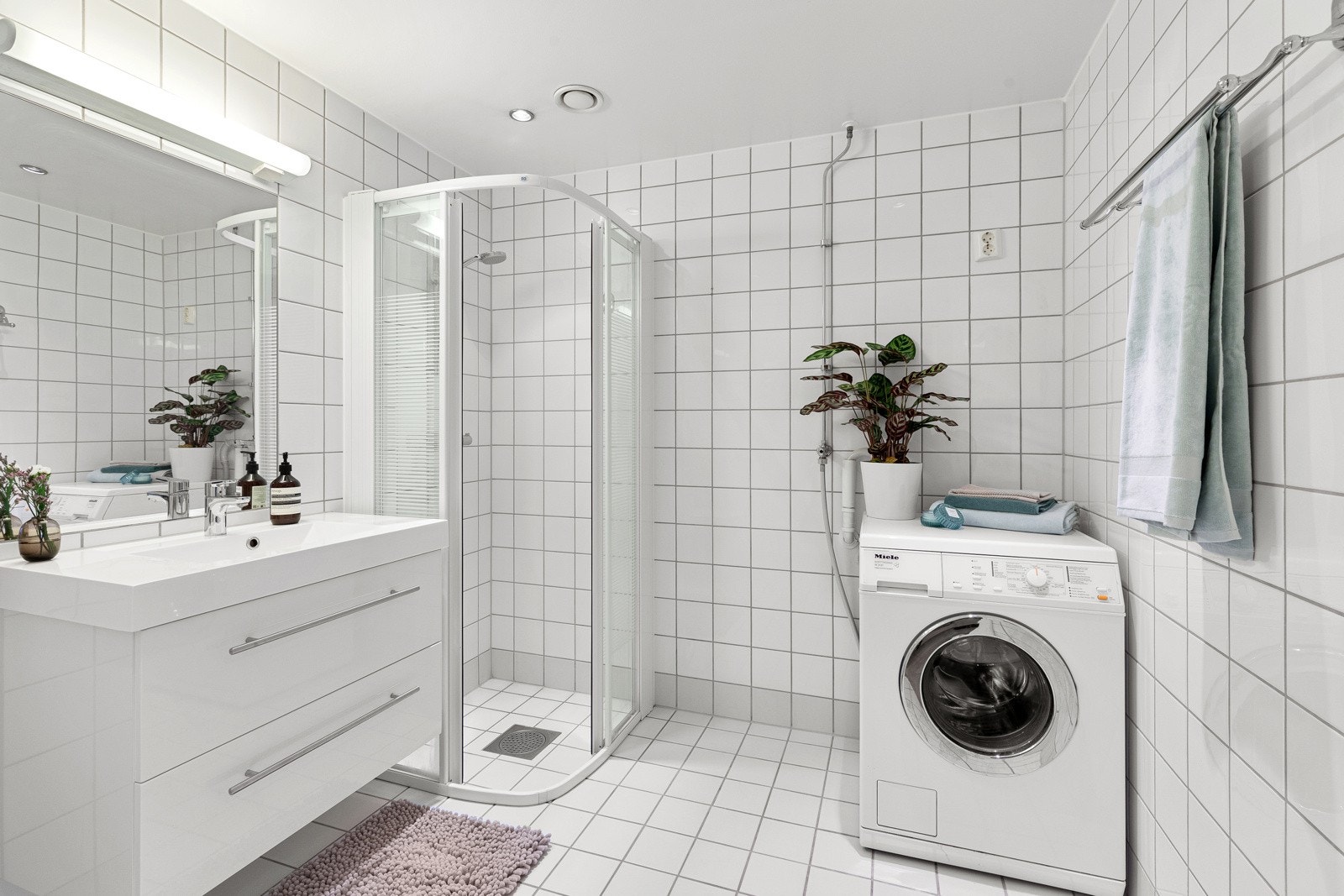 Lyst flislagt bad med opplegg for vaskemaskin Galleribilde