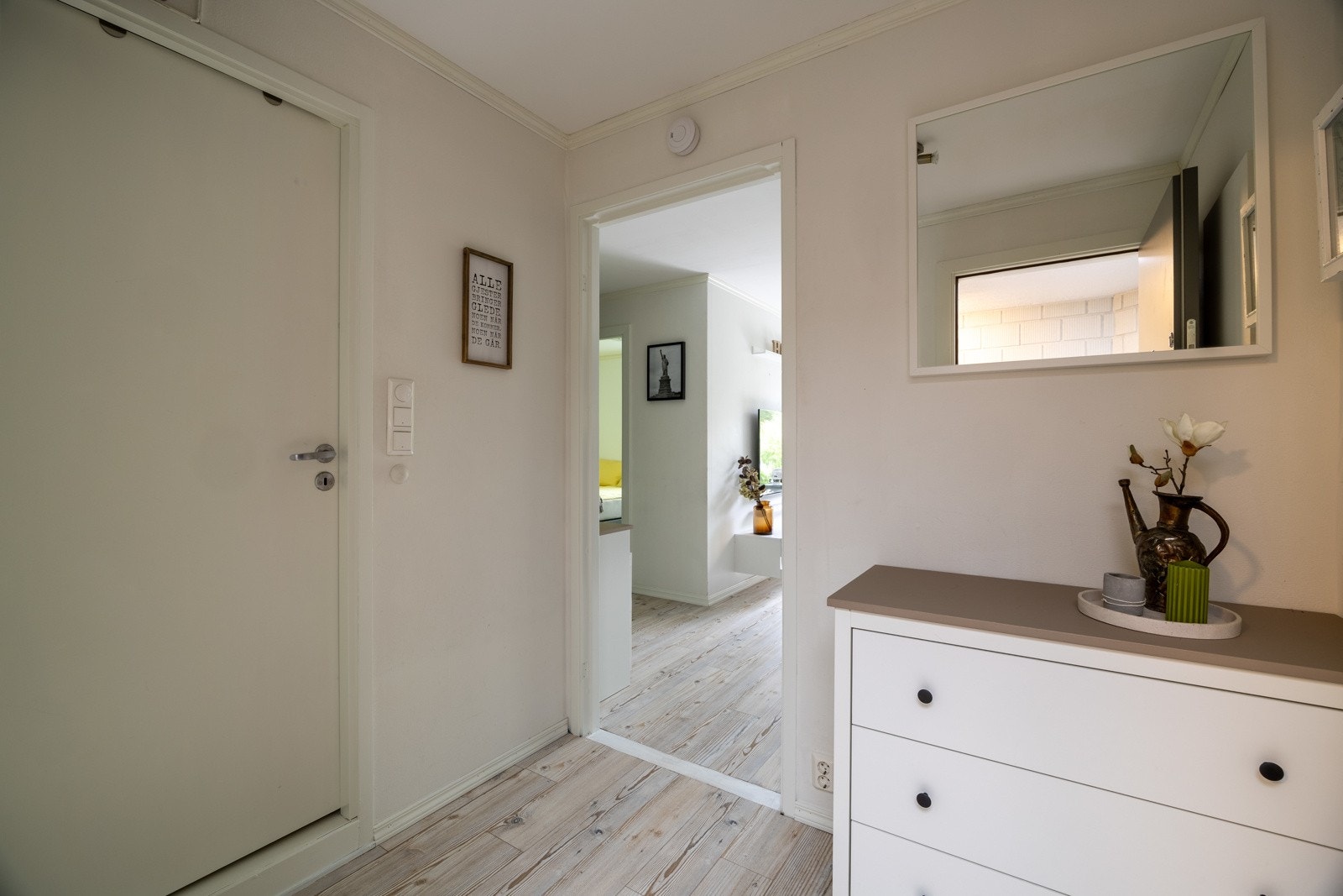 Du blir ønsket velkommen inn i en praktisk gang med oppheng til yttertøy og plass til sko Galleribilde