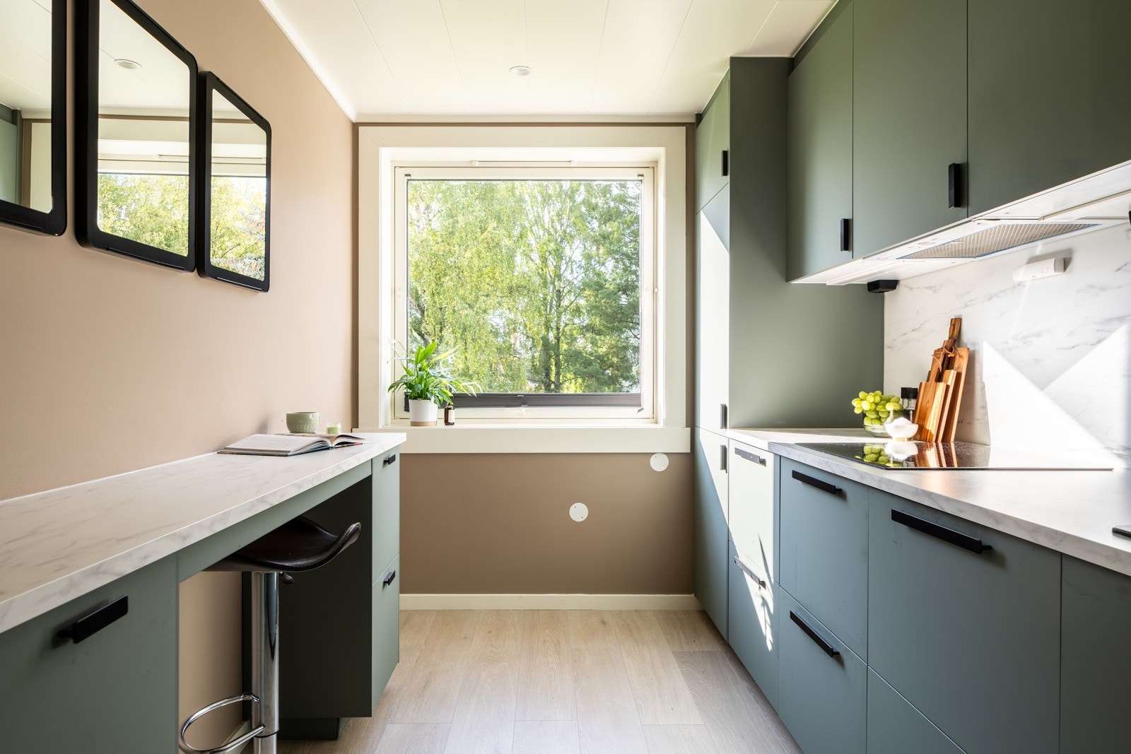 Leiligheten har et separat kjøkken med grønne fronter og benkeplate av laminat. Galleribilde