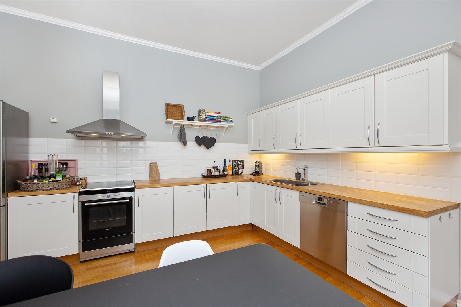 Flislagte felt på vegg over benkeplater av heltre Galleribilde