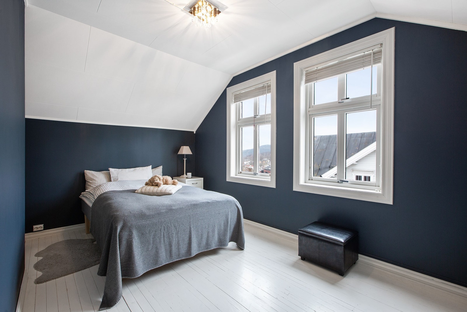 Soverom i loftetasjen med 1-stavs heltrebord på gulv, malte vegger og tak-ess i himling Galleribilde