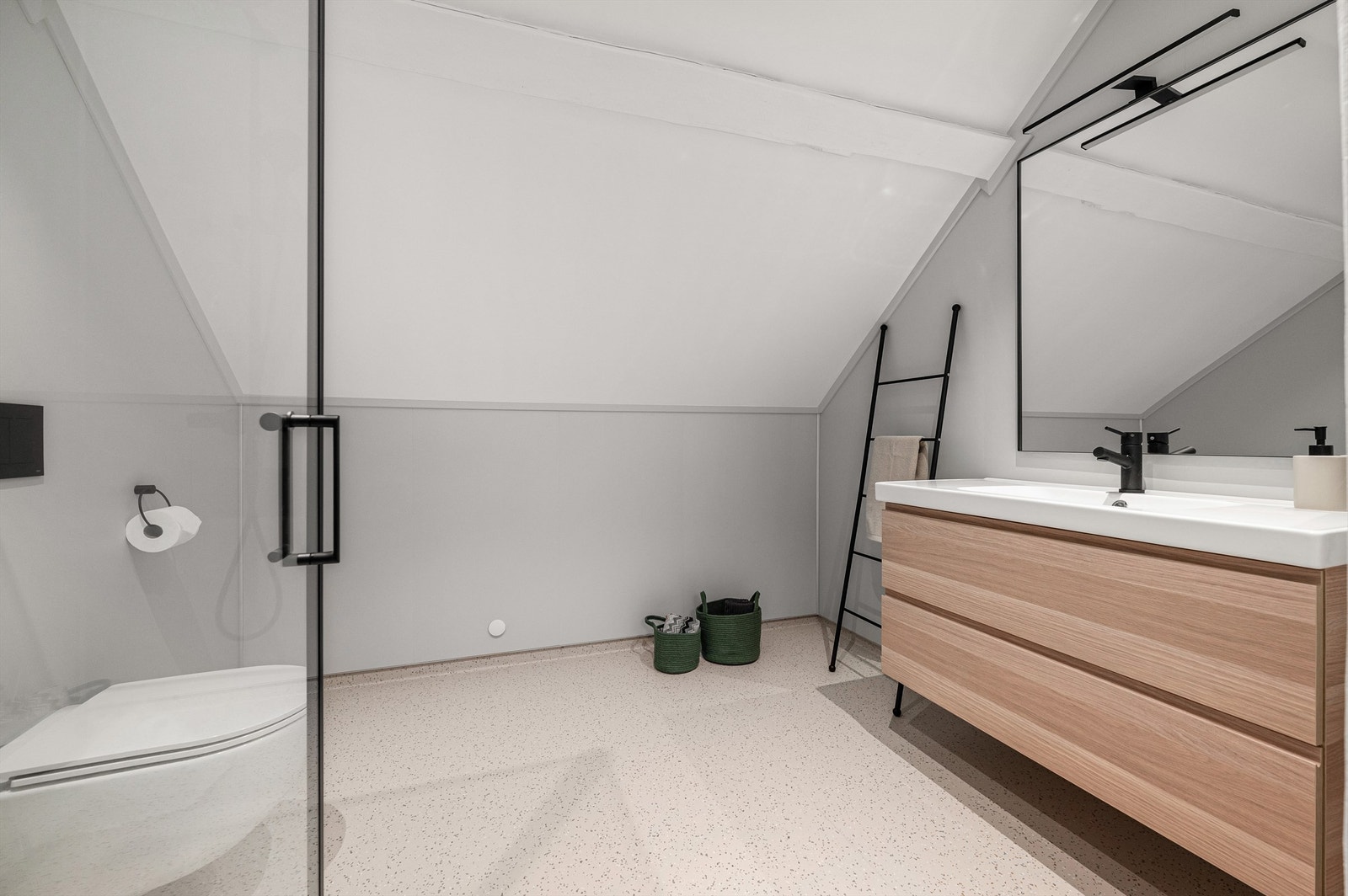 Flott og nytt bad fra 2024 med belegg på gulv, våtromsplater på vegger, dusjhjørne, vegghengt toalett og servant med skuffer. Stort speil på vegg, varmekabler i gulv. Galleribilde