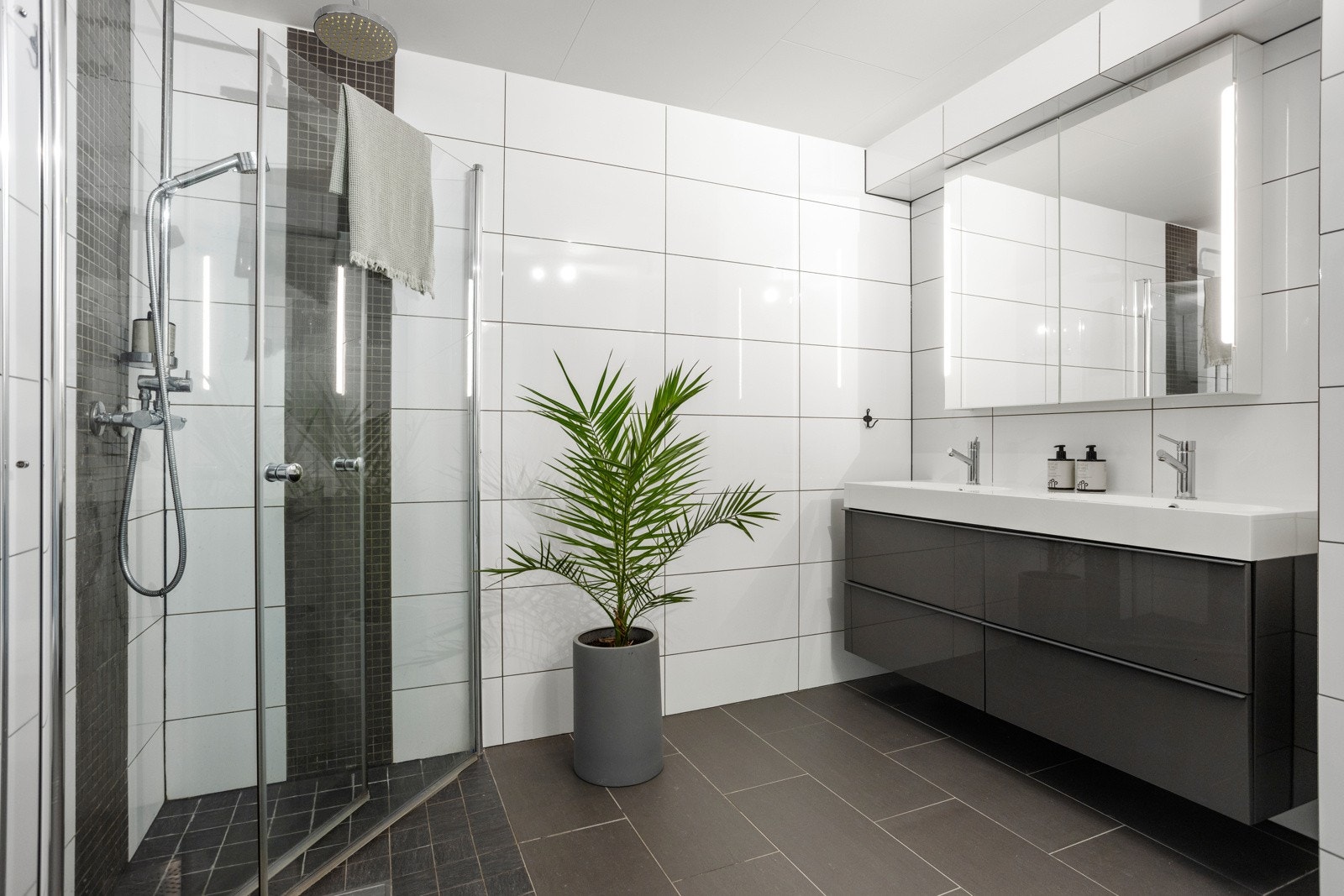 Badet ble pusset opp i 2014 og har gulvvarme, plass til vaskemaskin og tørketrommel, veggmontert toalett og et dusjhjørne med regnfallsdusj, hånddusj og innfellbare glassvegger Galleribilde