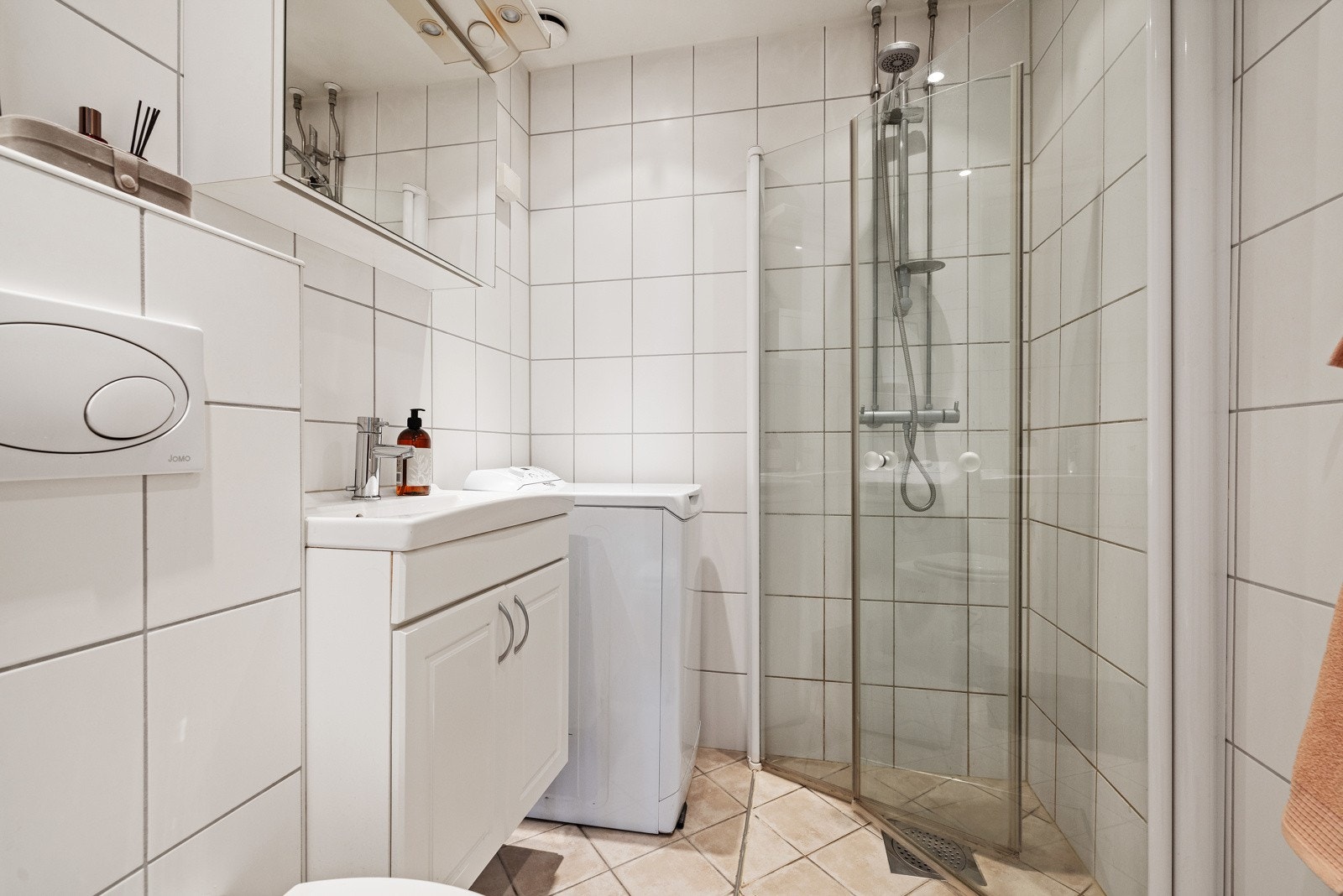 Badet er flislagt med varmekabler, opplegg for vaskemaskin og downlights i taket Galleribilde