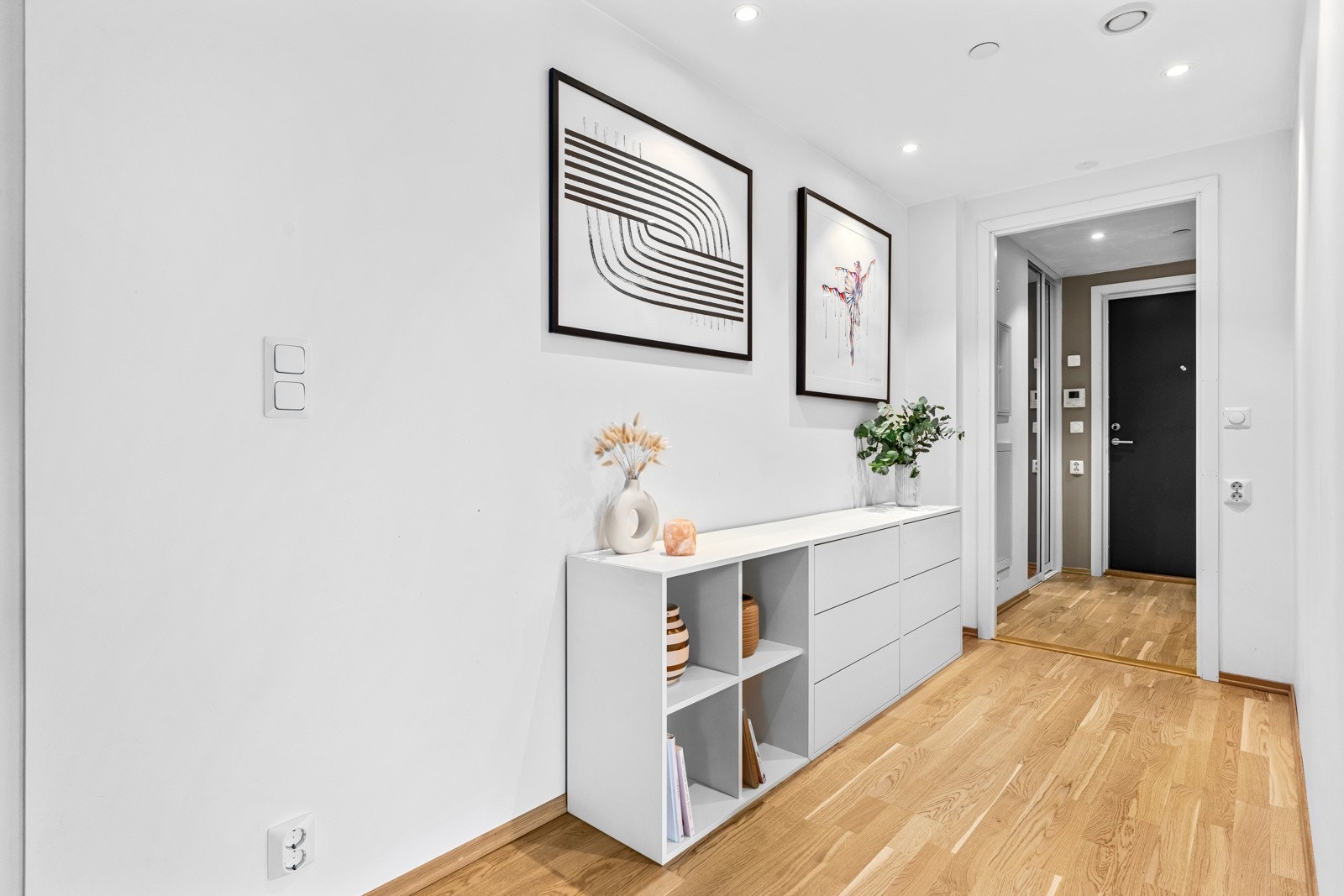 Entreen er innbydende med parkettgulv, glatte, mørke veggflater og listefri himling med downlights. Galleribilde