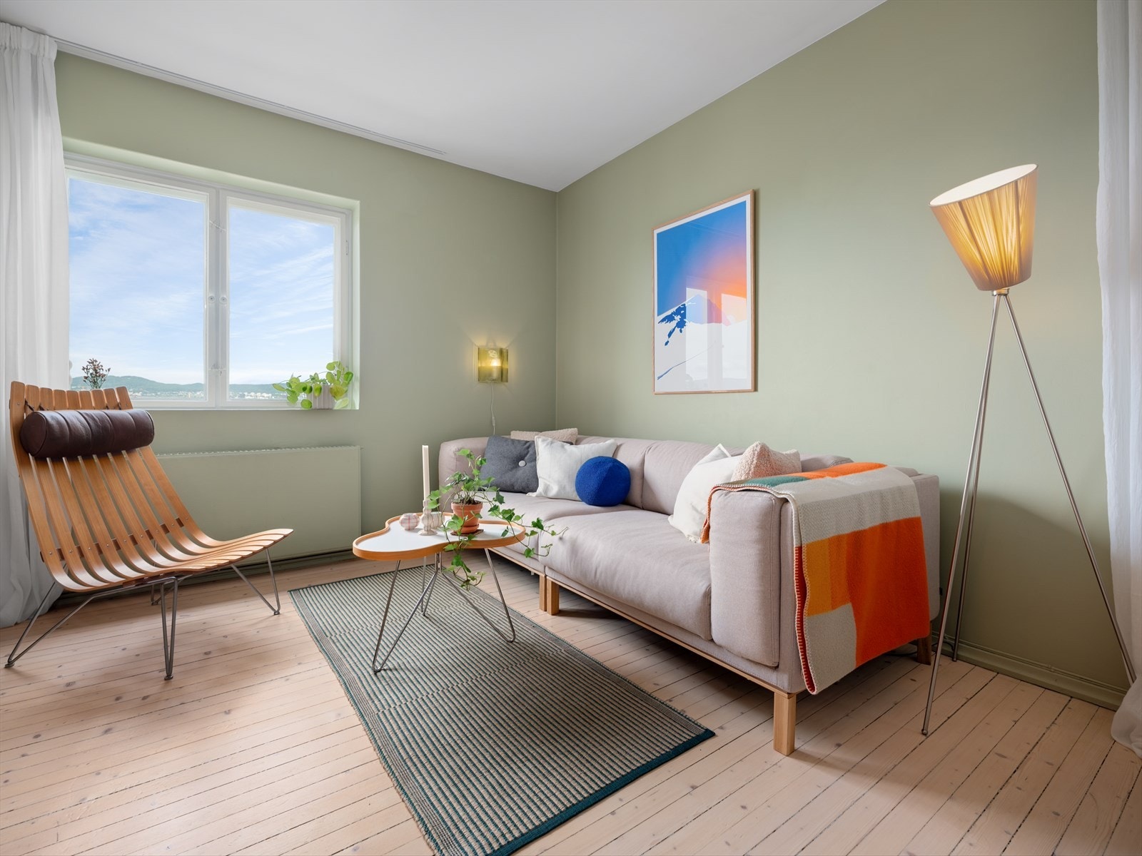 Vegger i stuen er malt i den dempede grønnfargen Laurbærblad fra Jotun. Rammen av peisen har den noe mørkere tonen Green Leaf også fra Jotun. Galleribilde