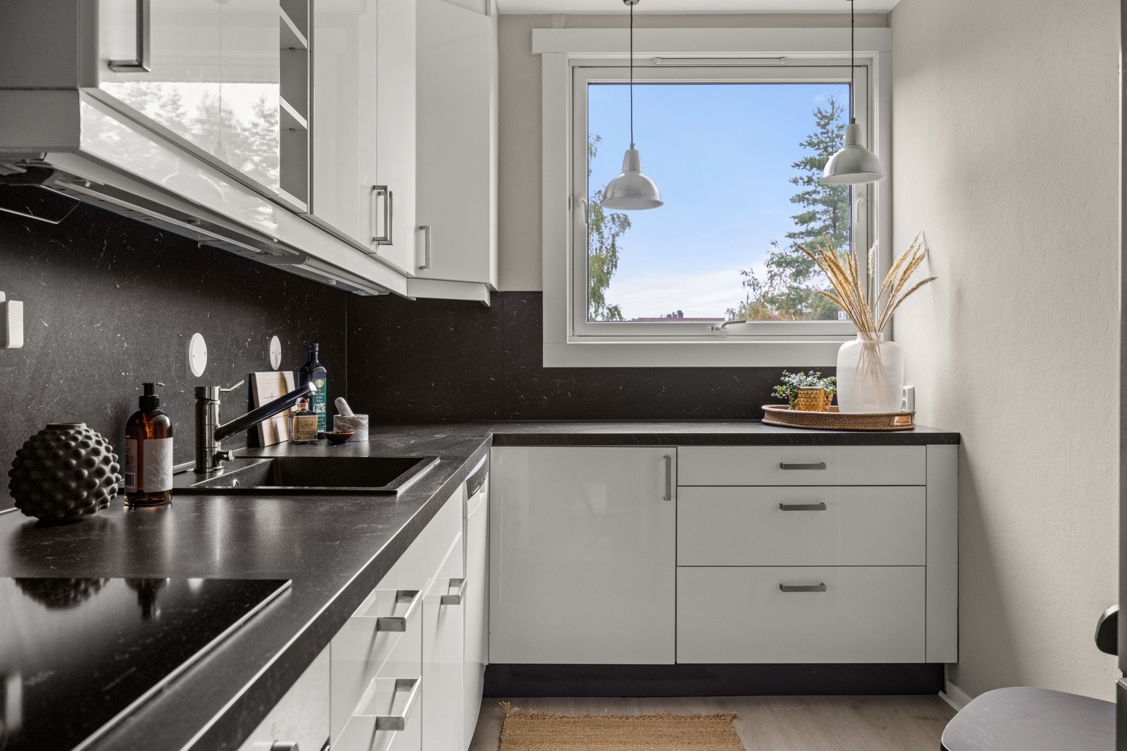 Moderne kjøkkeninnredning med hvite glatte fronter, benkeplate i laminat og oppvaskkum i kompositt. Galleribilde