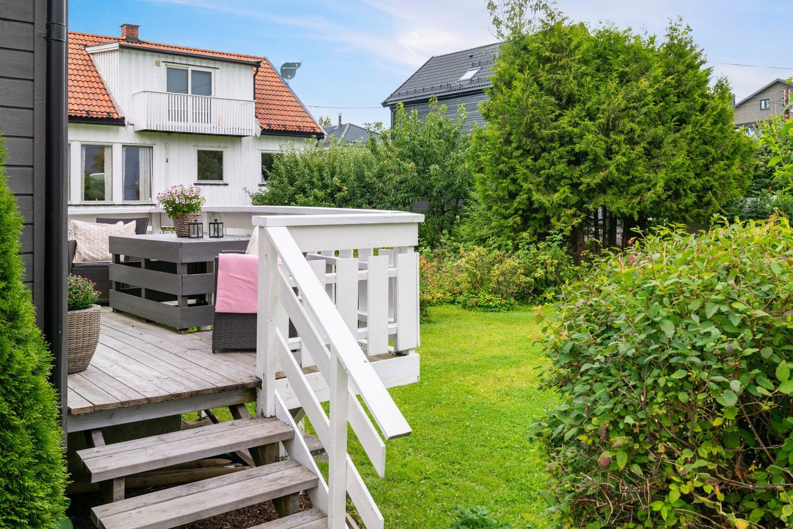 Fra stuen er det utgang til en solrik balkong med videre adkomst til en frodig hage Galleribilde